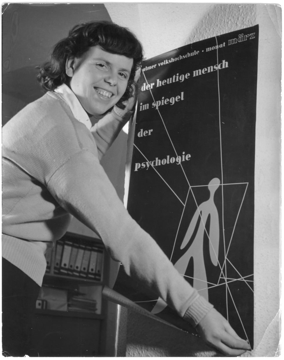 Inge Aicher-Scholl mit einem Plakat der Ulmer Volkshochschule (Museum Ulm/HfG-Archiv RR-P)