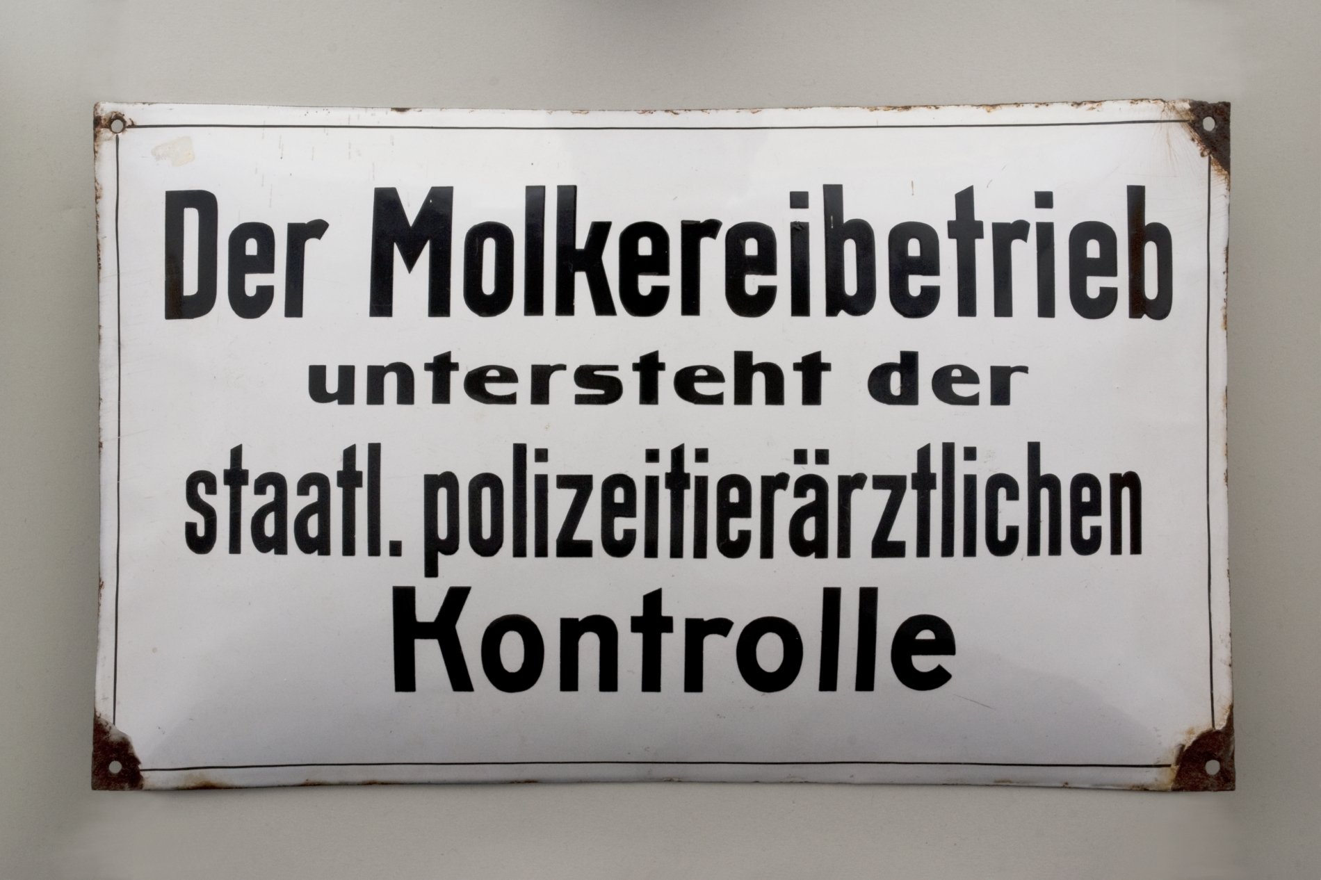 Hinweisschild "Der Molkereibetrieb untersteht der staatl. polizeitierärztlichen Kontrolle" (Stiftung Domäne Dahlem - Landgut und Museum, Weiternutzung nur mit Genehmigung des Museums CC BY-NC-SA)