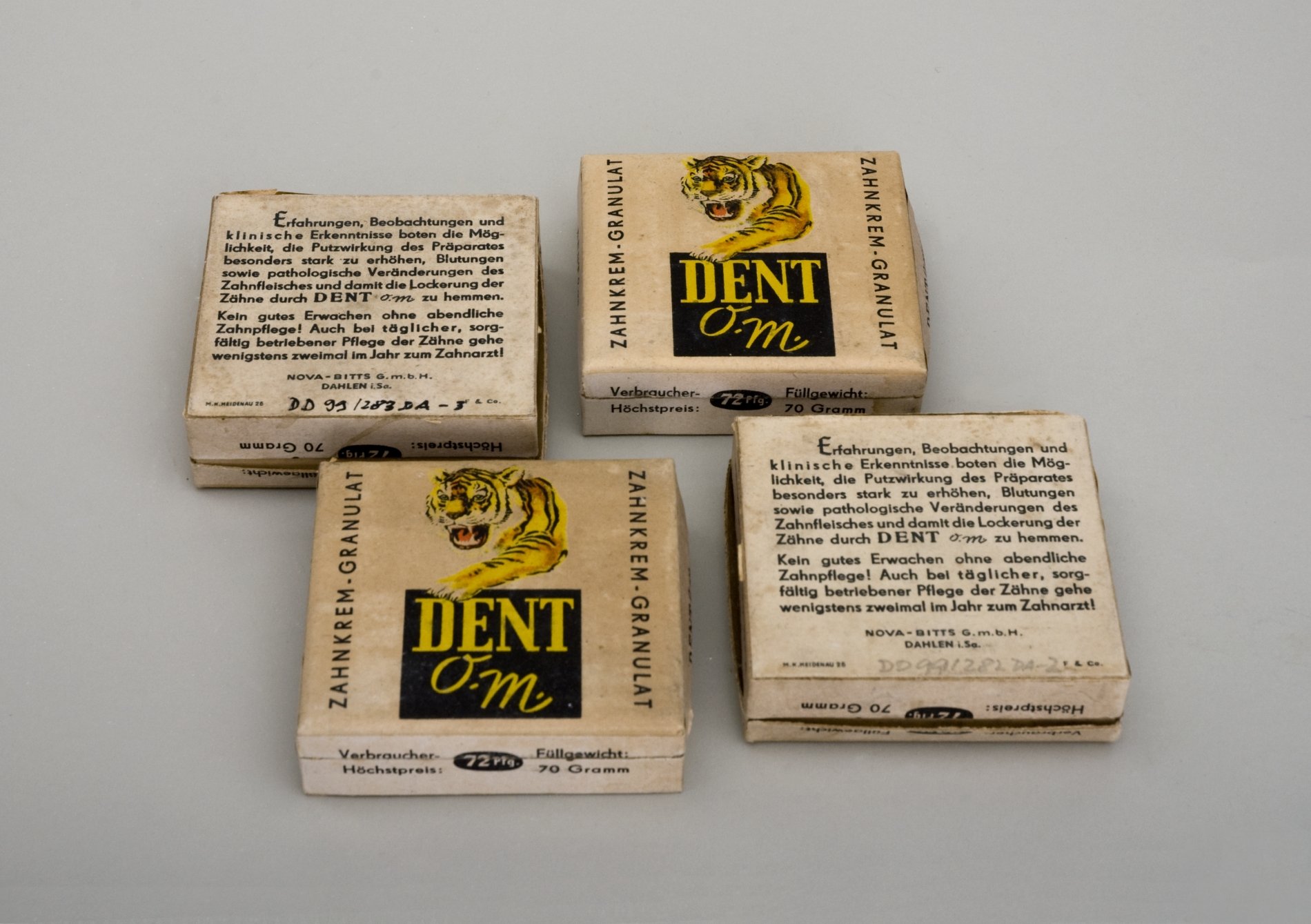 Vier Packungen "Dent O. M. Zahnkrem Granulat" (Stiftung Domäne Dahlem - Landgut und Museum, Weiternutzung nur mit Genehmigung des Museums CC BY-NC-SA)