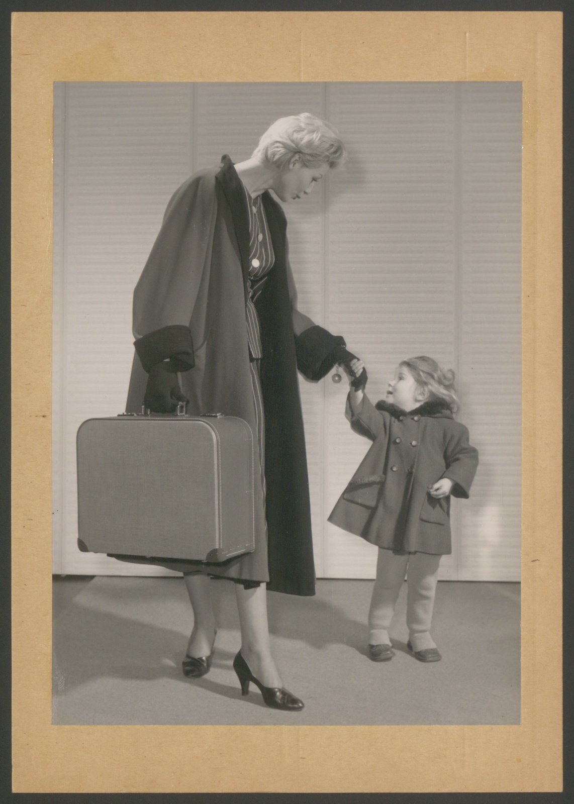 Fotografie: Frau mit Koffer für Zündapp-Nähmaschine sowie Kind an der Hand (Stiftung Deutsches Technikmuseum Berlin CC0)