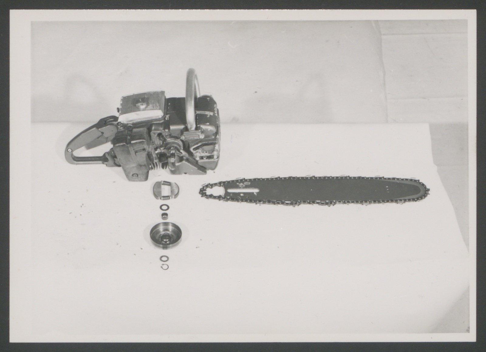 Fotografie: Seitenansicht eines Kettensägenmotors, abgenommenen Sägeblattes und einzelner Bauteile (Stiftung Deutsches Technikmuseum Berlin CC0)
