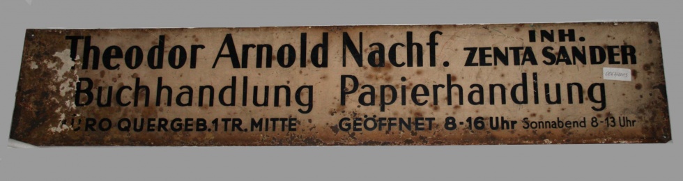 Schild mit Aufschrift: &quot;Theodor Arnold Nachf. Inh. ZENTA SANDER Buchhandlung Papierhandlung (Museum Pankow CC BY-NC-SA)