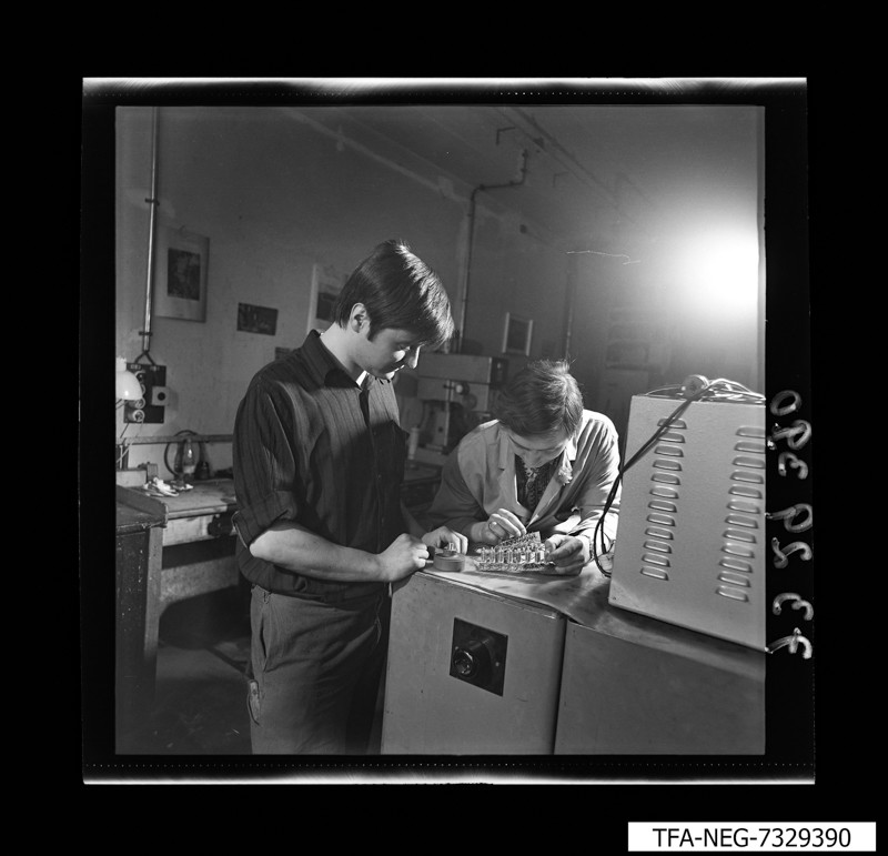 3 Mitarbeiter an einer mechanischen Prüfeinrichtung, Foto Dezember 1973 (www.industriesalon.de CC BY-NC-SA)