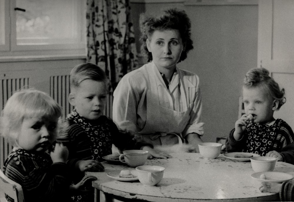 Drei Kinder und Erzieherin im Kinderheim; Foto, Juli 1954 (www.industriesalon.de CC BY-NC-SA)