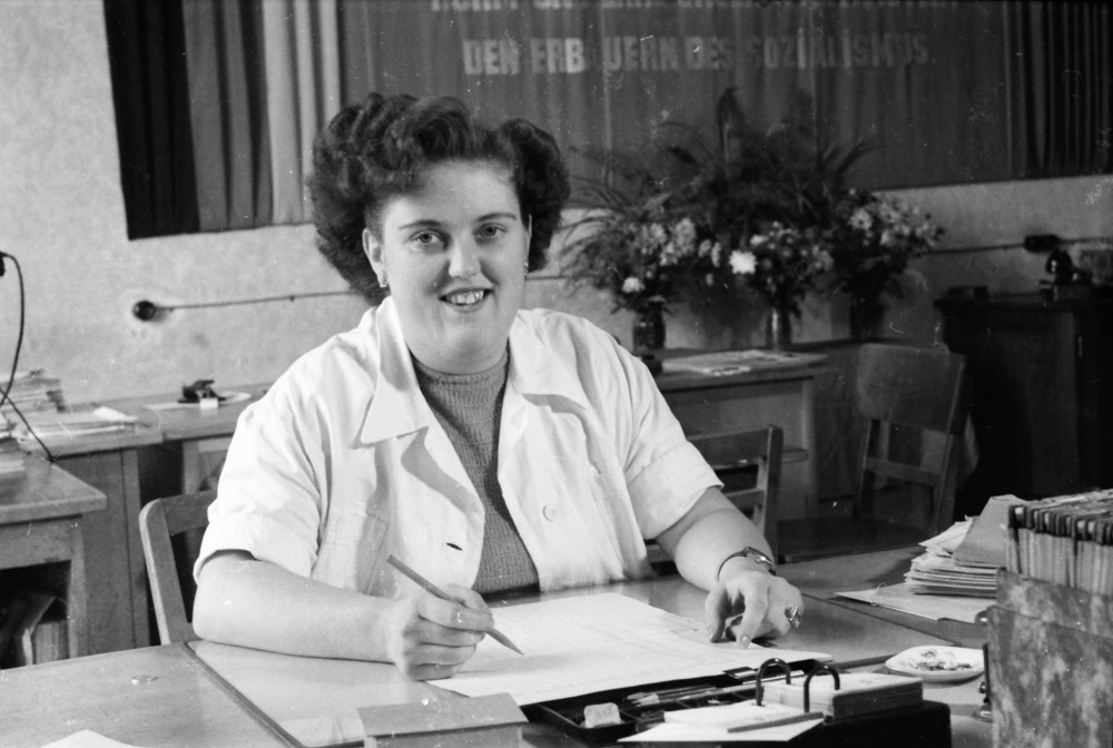 Junge Frau am Büroschreibtisch; Foto, Oktober 1955 (www.industriesalon.de CC BY-NC-SA)