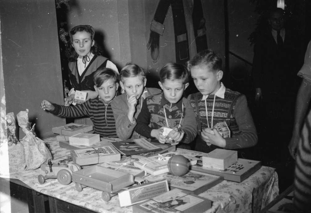 Kinderweihnachtsfest – Kinder vor Geschenktisch; Foto, Dezember 1954 (www.industriesalon.de CC BY-NC-SA)