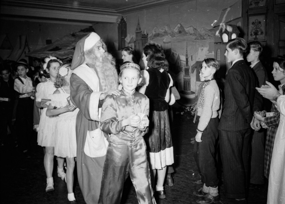 Kinderweihnachtsfest –Weihnachtsmann und kostümierte Kinder bei einer Polonaise; Foto, Dezember 1954 (www.industriesalon.de CC BY-NC-SA)