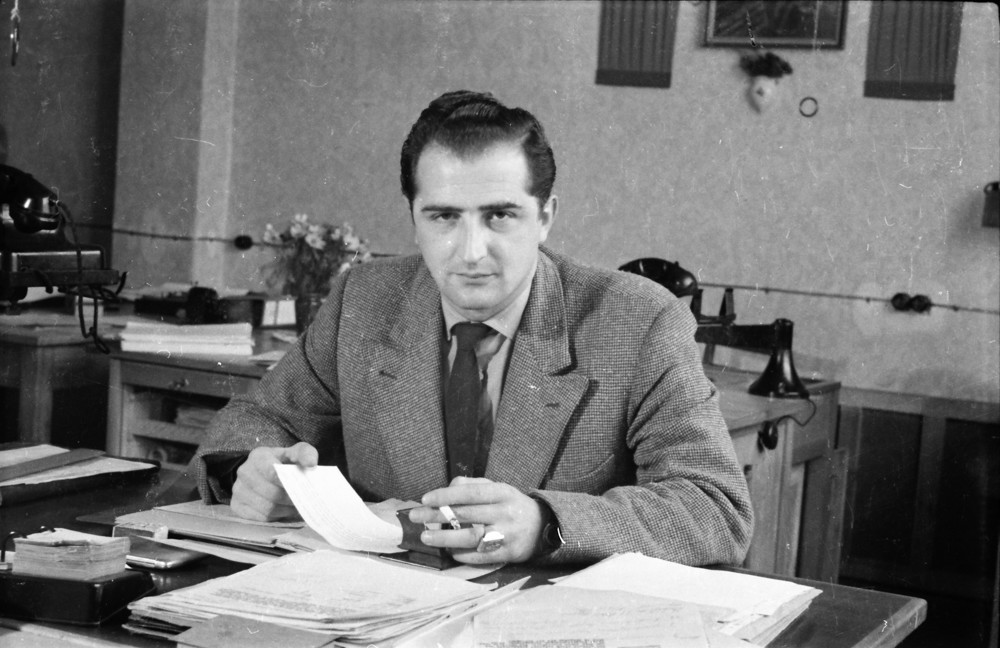 Mann mit Zigarette am Schreibtisch; Foto, Oktober 1955 (www.industriesalon.de CC BY-NC-SA)