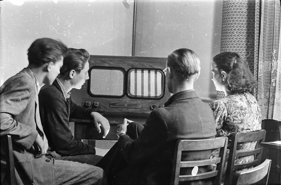 4 Personen vor einem HF-Fernseher.; Foto, 1954 (www.industriesalon.de CC BY-SA)