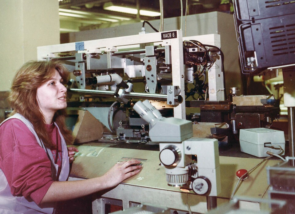 Mitarbeiterin an einer Produktionsanlage sitzend blickt auf einen Kontrollmonitor, Foto © Kurt Schwarz, 1980er Jahre. (Kurt Schwarz CC BY-NC-SA)