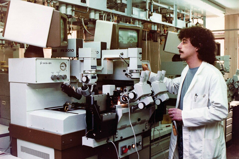 Mitarbeiter an einer Produktionsanlage blickt auf einen Kontrollmonitor, Farbfoto © Kurt Schwarz, 1980er Jahre (Kurt Schwarz CC BY-NC-SA)
