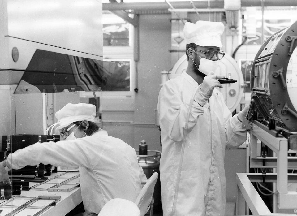 Zwei Mitarbeiter in Schutzanzügen in der Chip-Produktion des WF (Werk für Fernsehelektronik, Berlin Oberschöneweide), Foto © Kurt Schwarz, ca. 1982. (Kurt Schwarz CC BY-NC-SA)