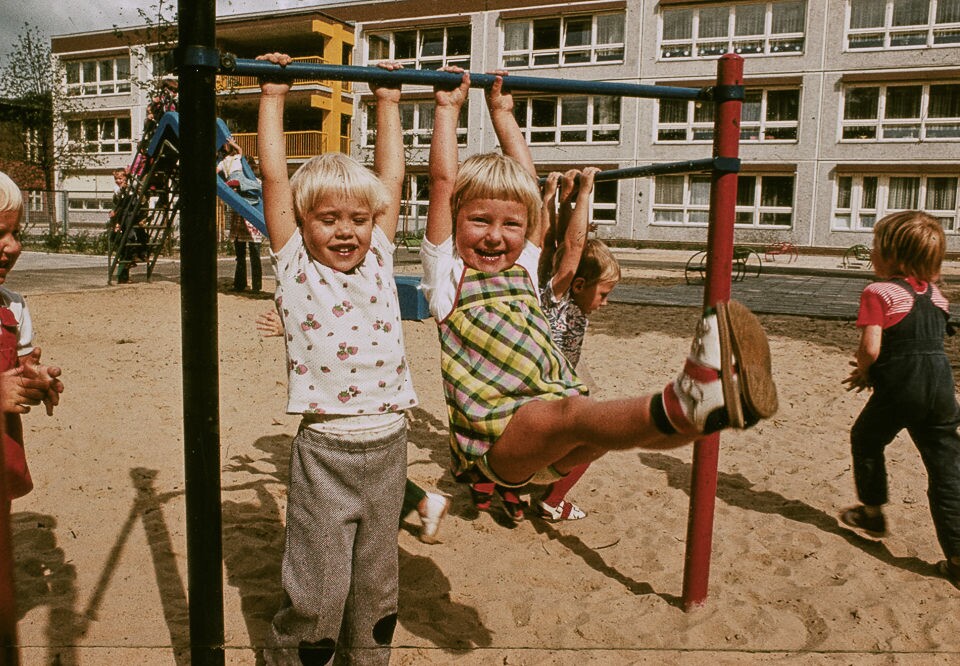 Kinder auf dem Spielplatz vor dem Gebäude des WF Kindergartens, Farbfoto © Kurt Schwarz, 1980er Jahre (Kurt Schwarz CC BY-NC-SA)
