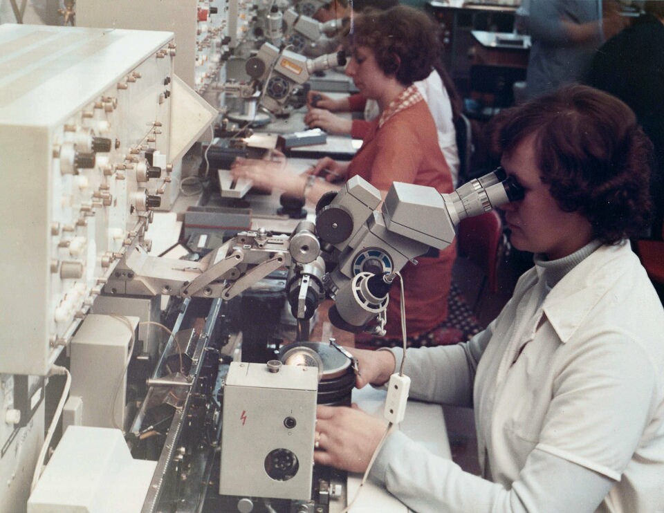 Mitarbeiterinnen mit Mikroskopen in der Diodenproduktion des WF, Farbfoto © Kurt Schwarz, 1980er Jahre (Kurt Schwarz CC BY-NC-SA)