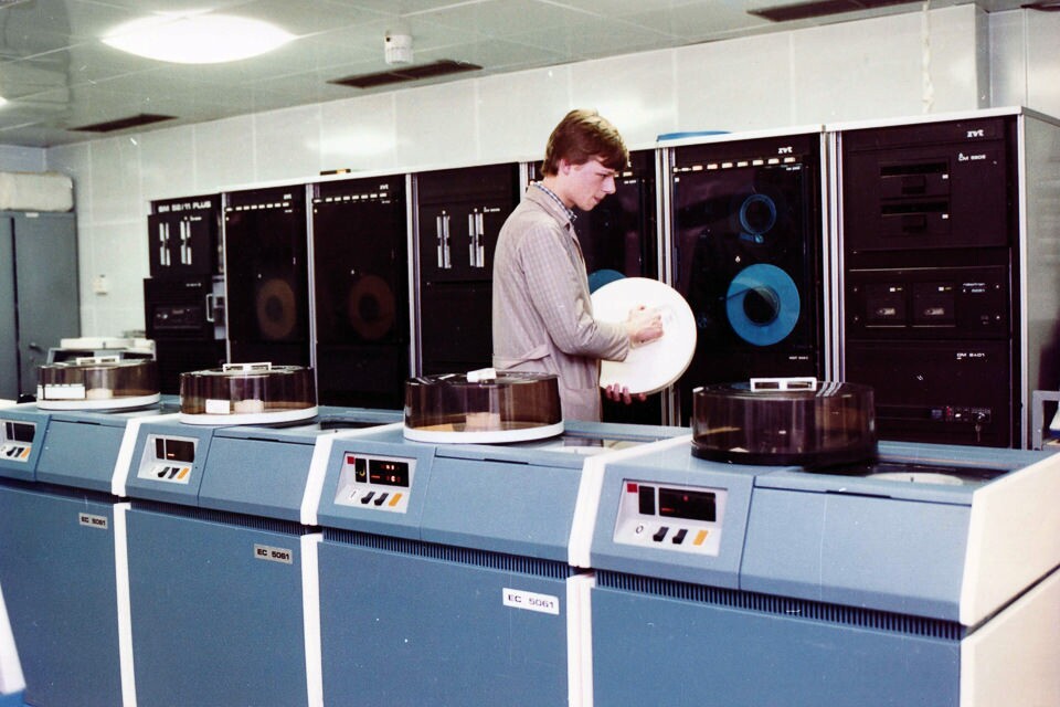 Junger Mitarbeiter mit Magnetband im Rechenzentrum des WF, Farbfoto © Kurt Schwarz, 1980er Jahre (Kurt Schwarz CC BY-NC-SA)