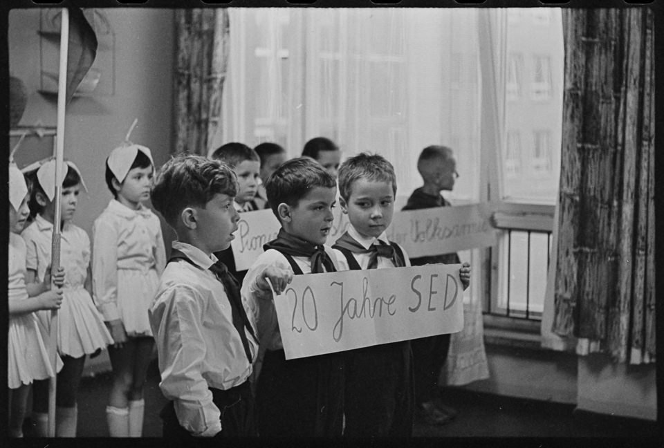 Erstklässler halten in einem Klassenzimmer ein Plakat mit der Aufschrift "20 Jahre SED", 1966. SW-Foto © Kurt Schwarz. (Kurt Schwarz CC BY-NC-SA)