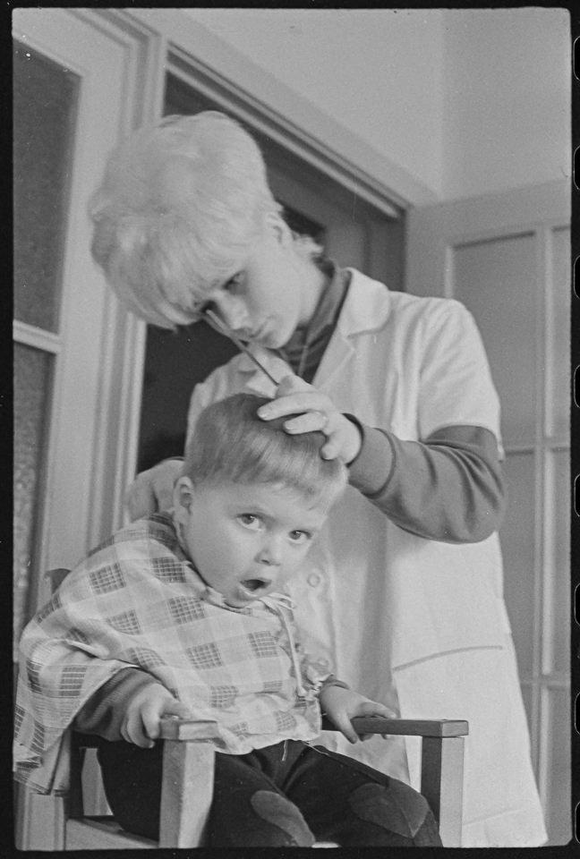 Friseurin beim Haareschneiden in einer Kinderkrippe, Bild 2, 1969. SW-Foto © Kurt Schwarz. (Kurt Schwarz CC BY-NC-SA)