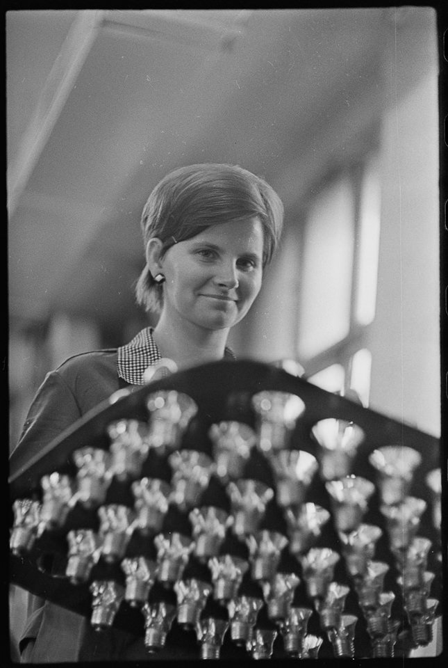 VEB Narva Kombinat, Bild 6: Junge Mitarbeiterin hinter einem mit Glühbirnen bestücktem Brett. SW-Foto, 1969 © Kurt Schwarz. (Kurt Schwarz CC BY-NC-SA)