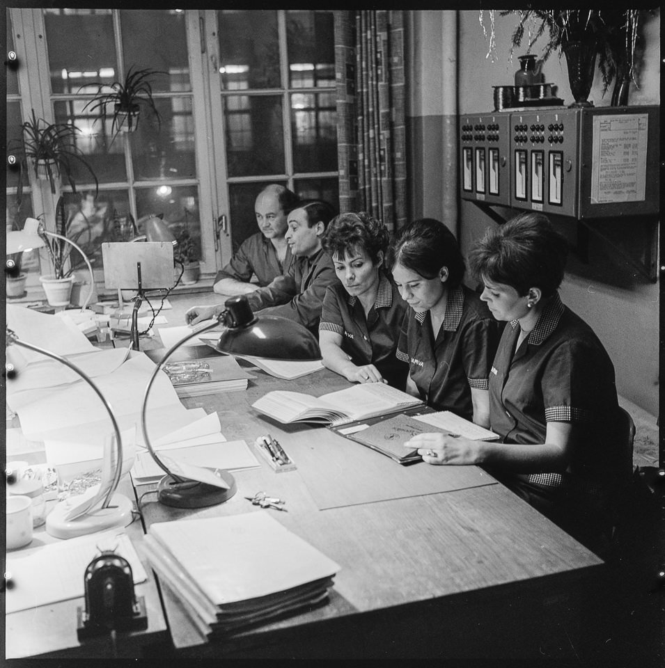VEB Narva Kombinat, Bild 20: Drei Frauen und zwei Männer sitzen in einem Büro an einem Tisch. SW-Foto, 1969 © Kurt Schwarz. (Kurt Schwarz CC BY-NC-SA)
