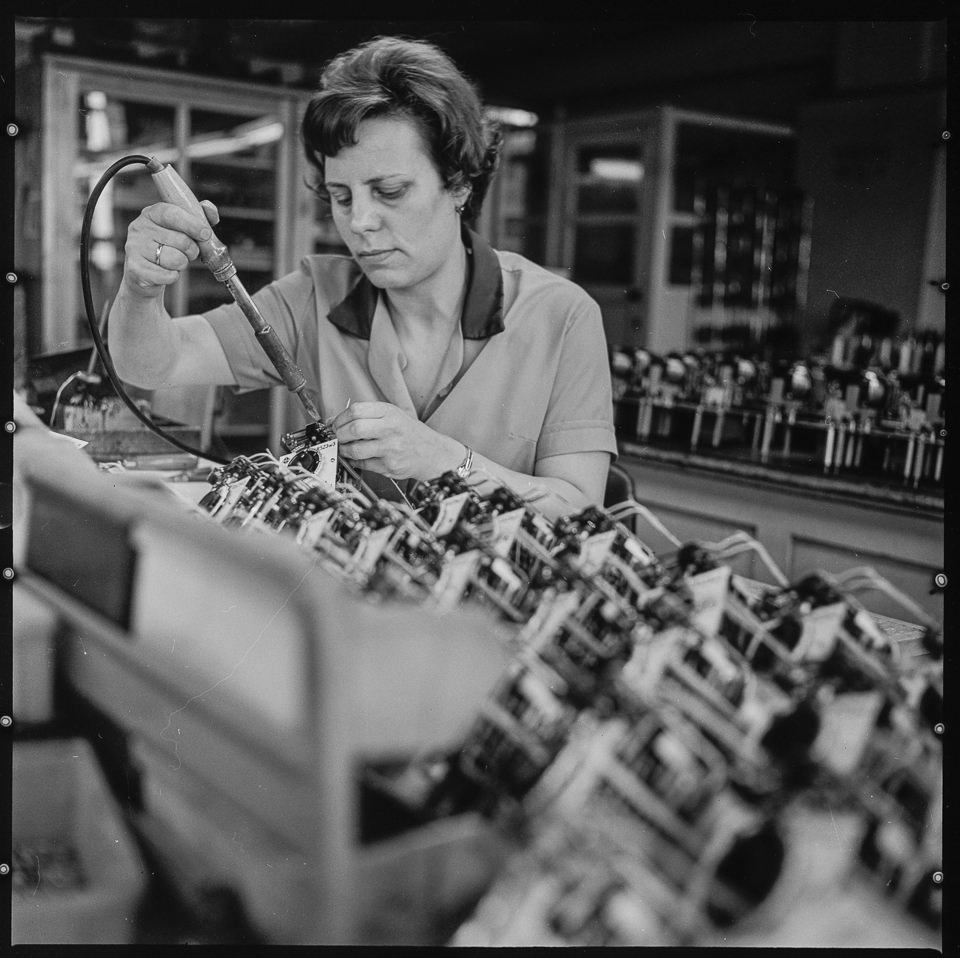 VEB Elektro-Apparate-Werke Berlin-Treptow „Friedrich Ebert“ (EAW), Bild 1: Frau mit Lötkolben bei der Arbeit. SW-Foto, 1960er Jahre © Kurt Schwarz. (Kurt Schwarz CC BY-NC-SA)
