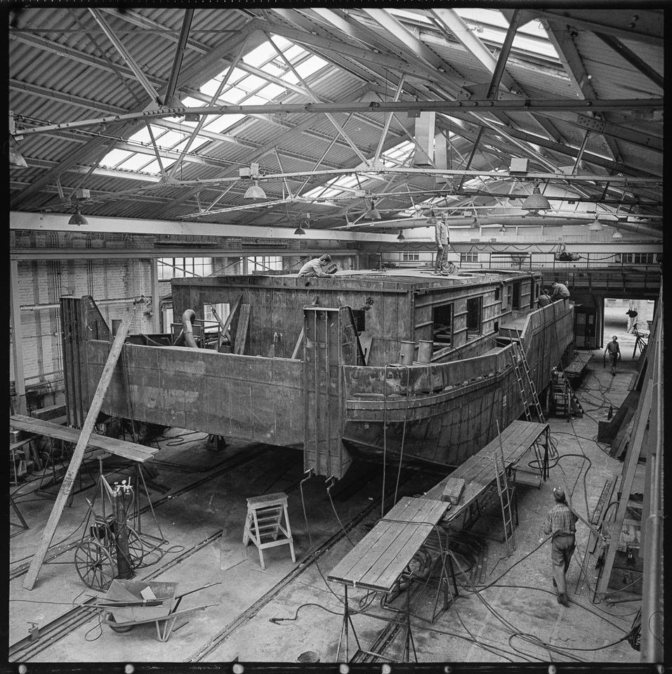 VEB Kombinat Schiffbau, Bild 1: Blick in die Produktionshalle in Berlin Köpenick, wo ein Schubboot gebaut wird. SW-Foto, 1960er Jahre © Kurt Schwarz. (Kurt Schwarz CC BY-NC-SA)