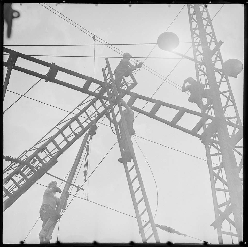 Arbeiter beim Installieren von Stromleitungen. SW-Foto, wahrscheinlich 1960er Jahre © Kurt Schwarz. (Kurt Schwarz CC BY-NC-SA)