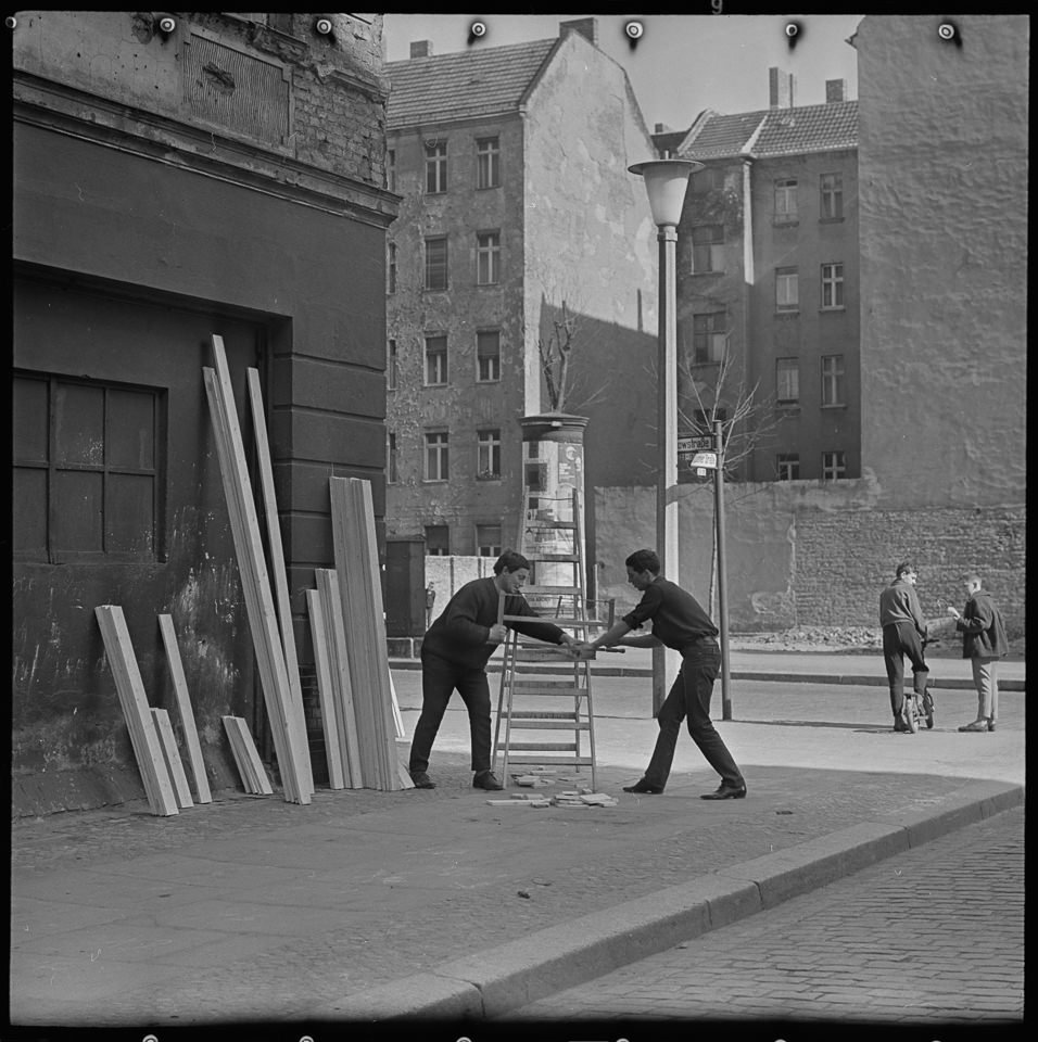 Straßen - Kurioses, Bild 1: Zwei Männer bei Holzarbeiten an einer Straßenecke. SW-Foto, 1960er Jahre © Kurt Schwarz. (Kurt Schwarz CC BY-NC-SA)