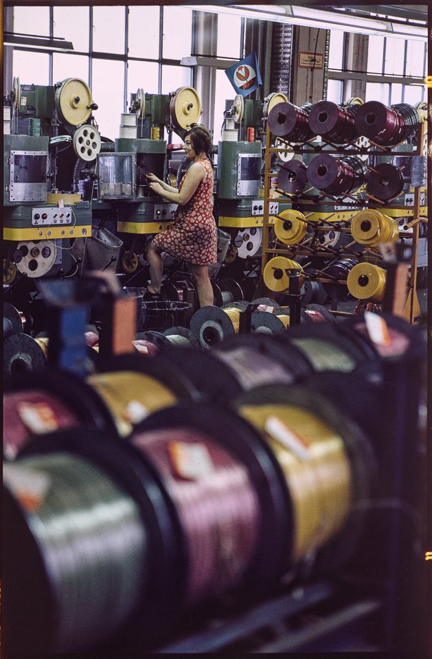 Kabelwerk Oberspree (KWO), Bild 5: Mitarbeiterin in der Kabelproduktion. Farbfoto, 1970er Jahre © Kurt Schwarz. (Kurt Schwarz CC BY-NC-SA)