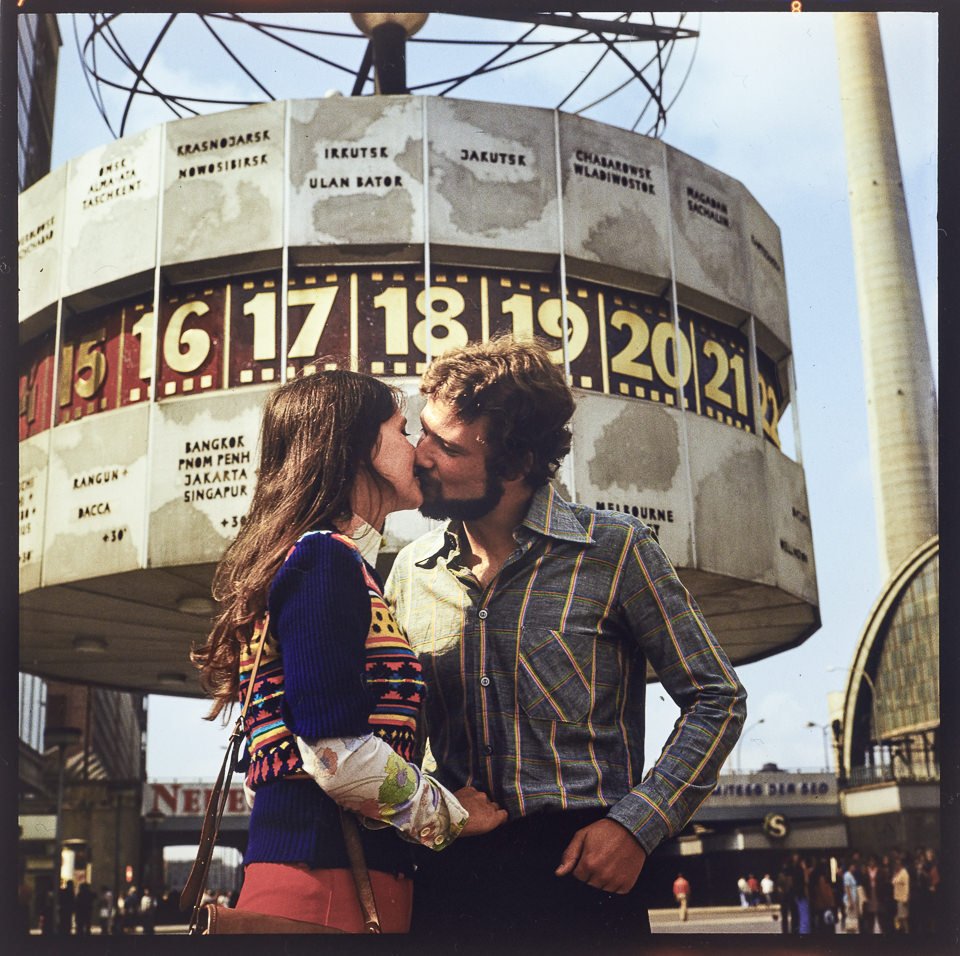 Junges Paar beim Kuss vor der Weltzeituhr am Alexanderplatz. Farbfoto, 1970er Jahre © Kurt Schwarz. (Kurt Schwarz CC BY-NC-SA)