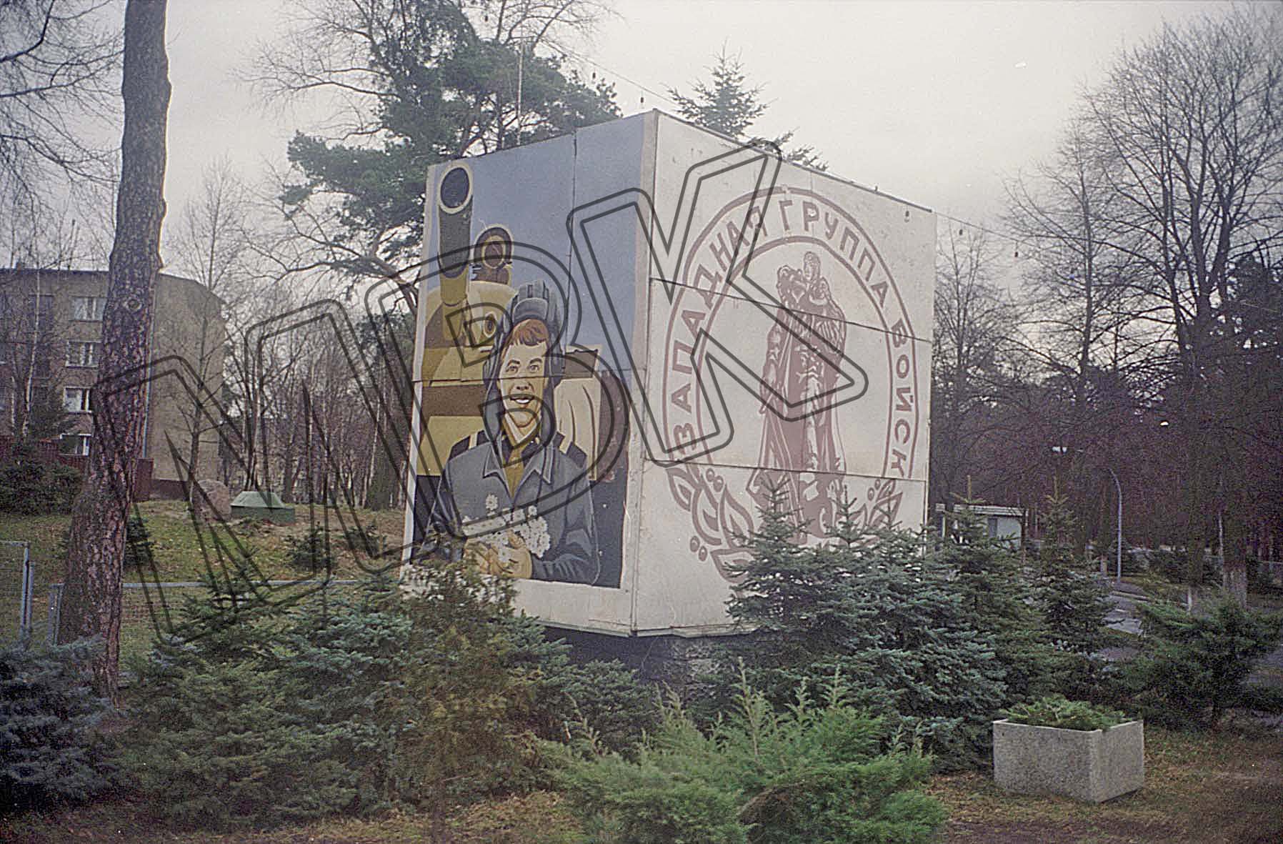 Fotografie: Stellage mit Propagandatafel in einem Wohngebiet der Garnison, Wünsdorf, vermutlich 1994 (Museum Berlin-Karlshorst RR-P)