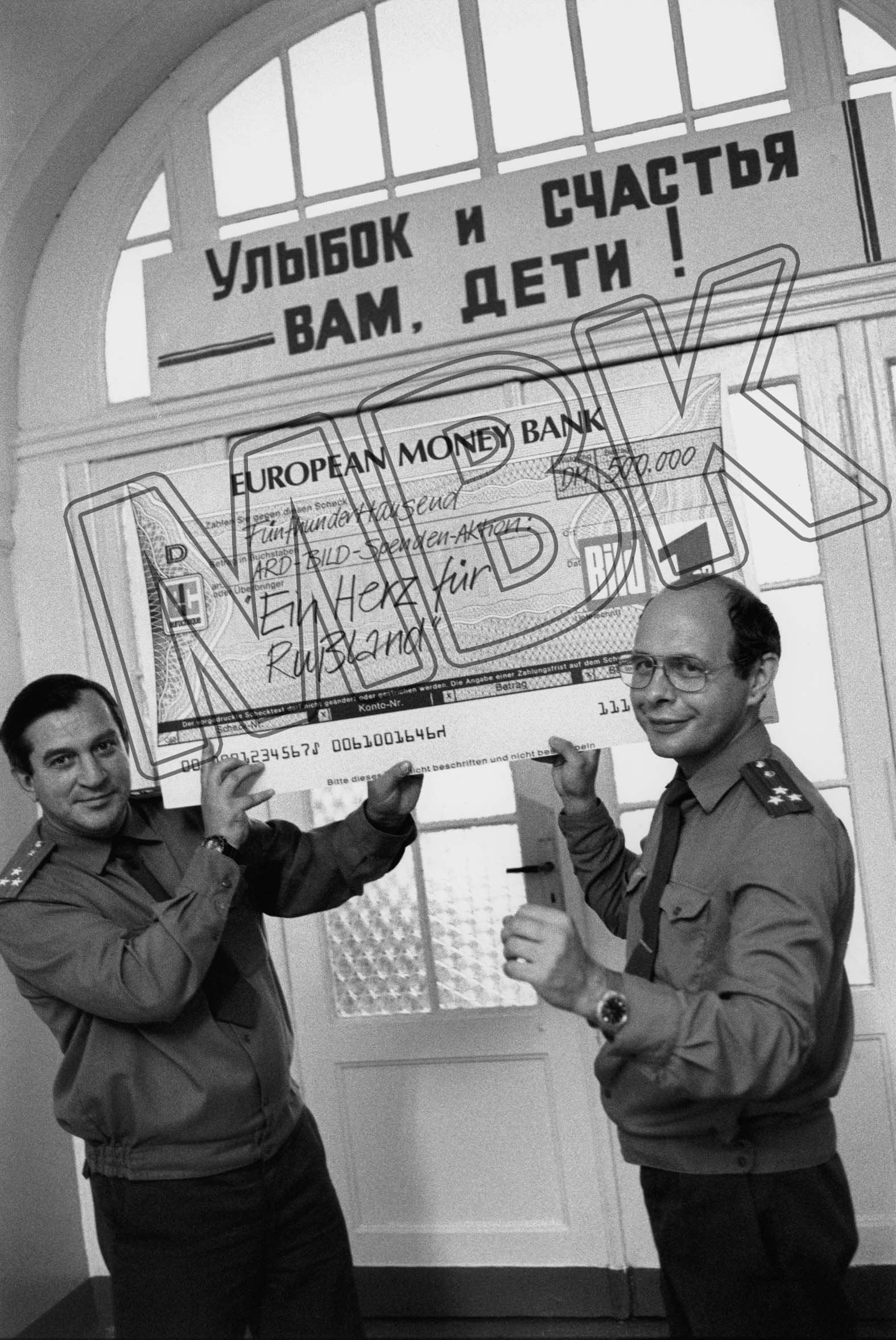 Fotografie: Zwei russische Offiziere mit einem Scheck von der ARD-Bild-Spendenaktion im zentralen Militärkrankenhaus der WGT in Beelitz, 31. August 19 (Museum Berlin-Karlshorst RR-P)