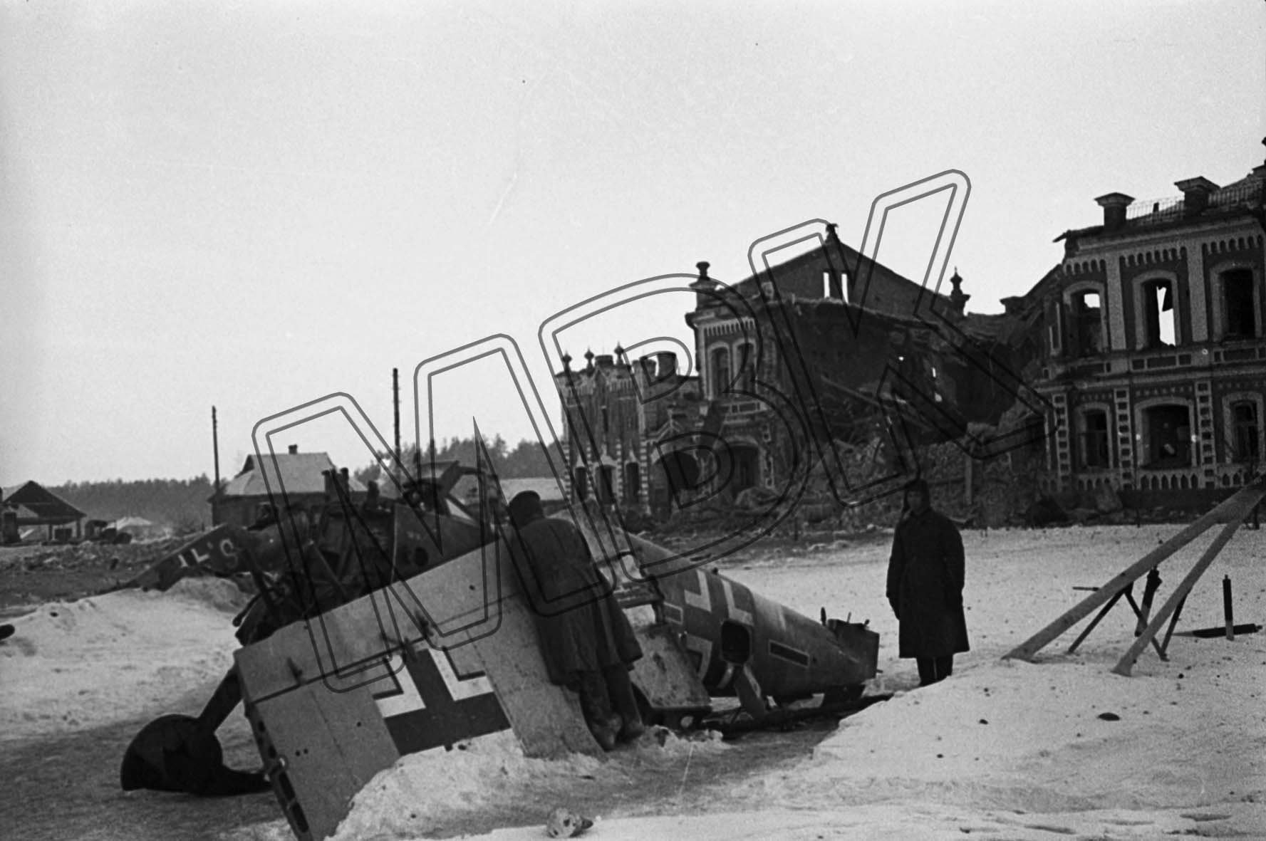 Fotografie: Abgeschossenes deutsches Militärflugzeug in der zerstörten Stadt Juchnow, Gebiet Kaluga, 6. März 1942 (Museum Berlin-Karlshorst RR-P)