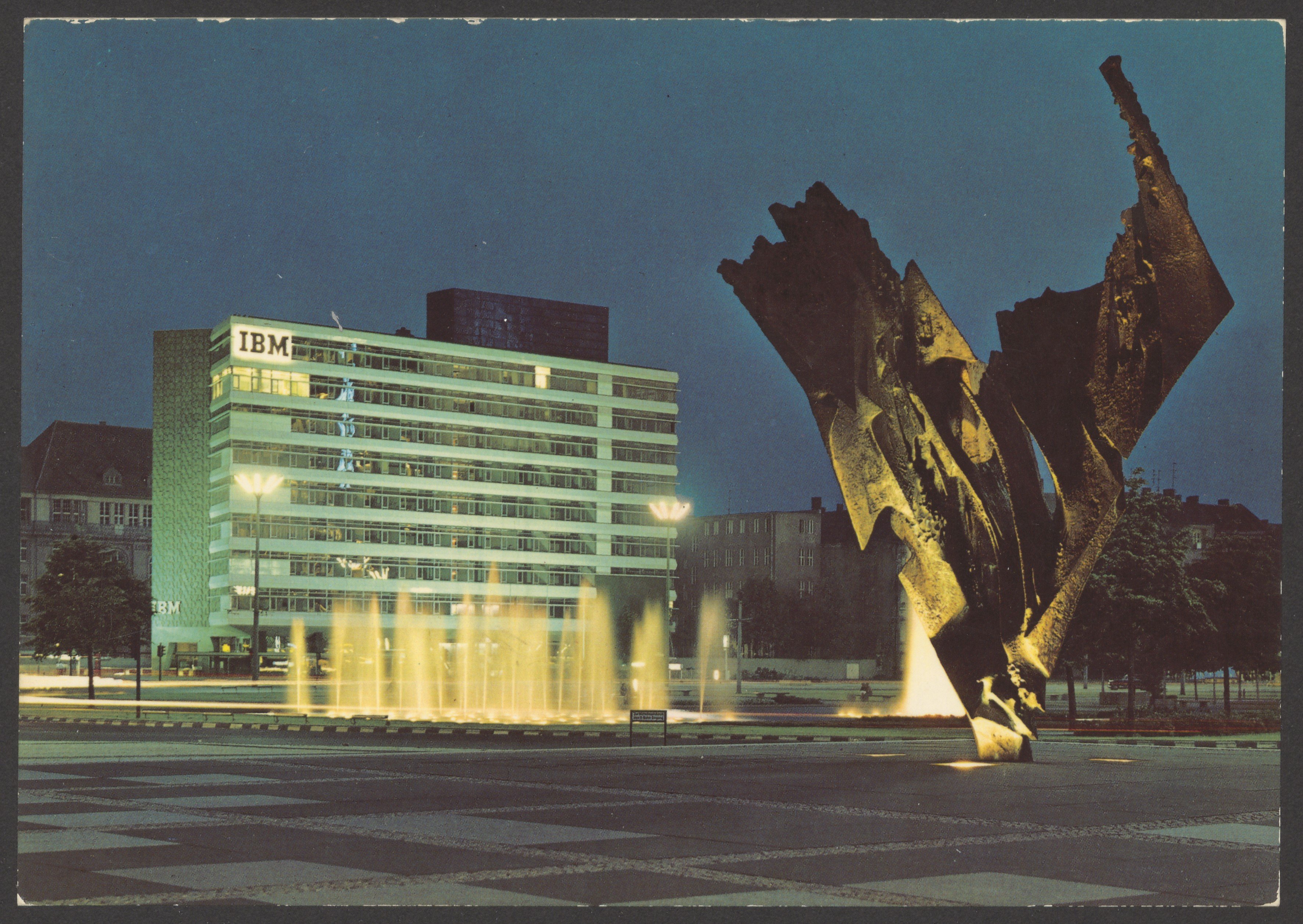Postkartendruck der Farbfotographie von Bernhard Heiligers Skulptur „Flamme“ auf dem Ernst Reuter-Platz bei Nacht (Bernhard-Heiliger-Stiftung CC BY-NC)