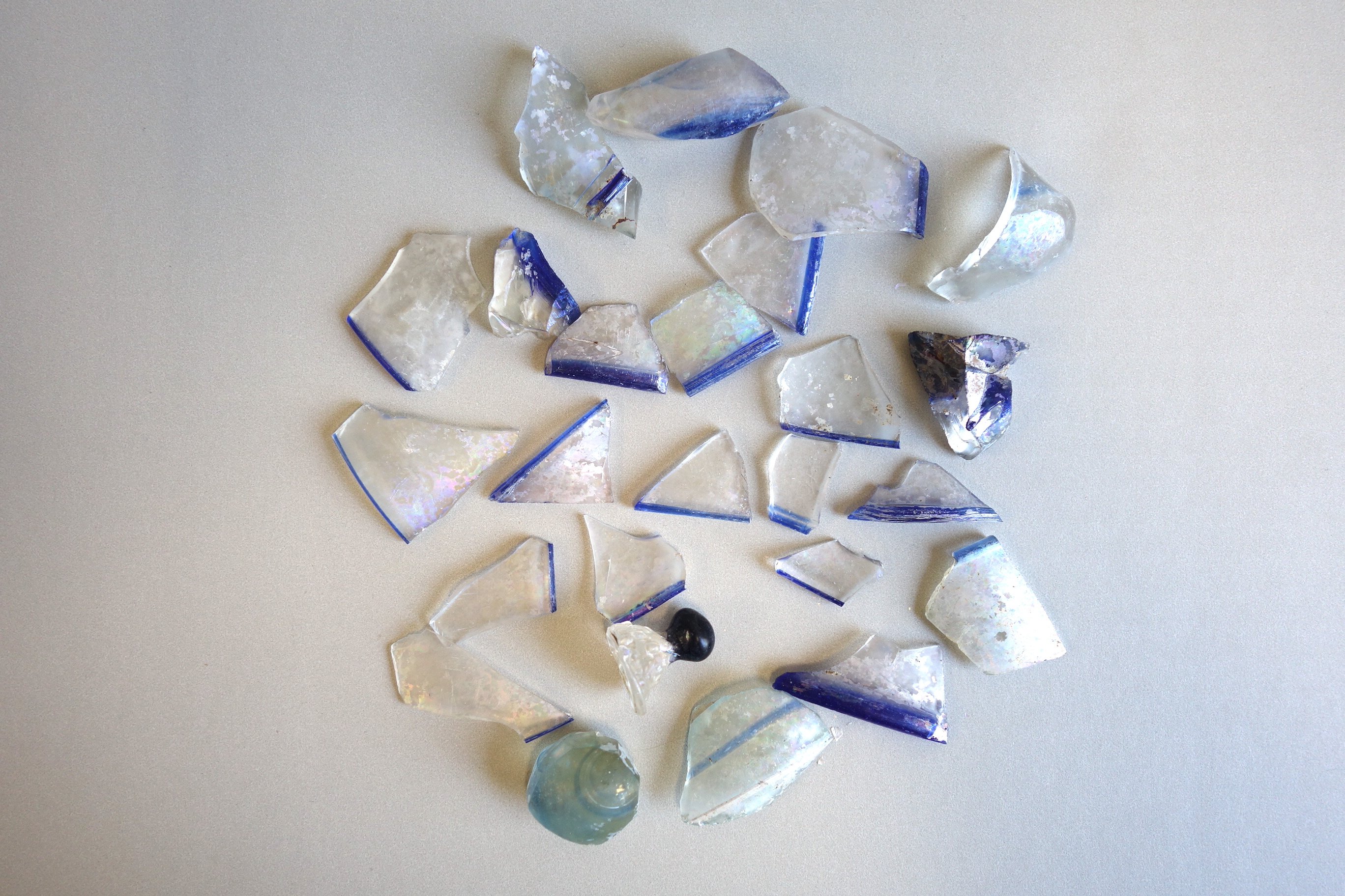 25 Fragmente von farblosem Glas mit blauen Zierelementen (Potsdam Museum – Forum für Kunst und Geschichte CC BY-NC-SA)