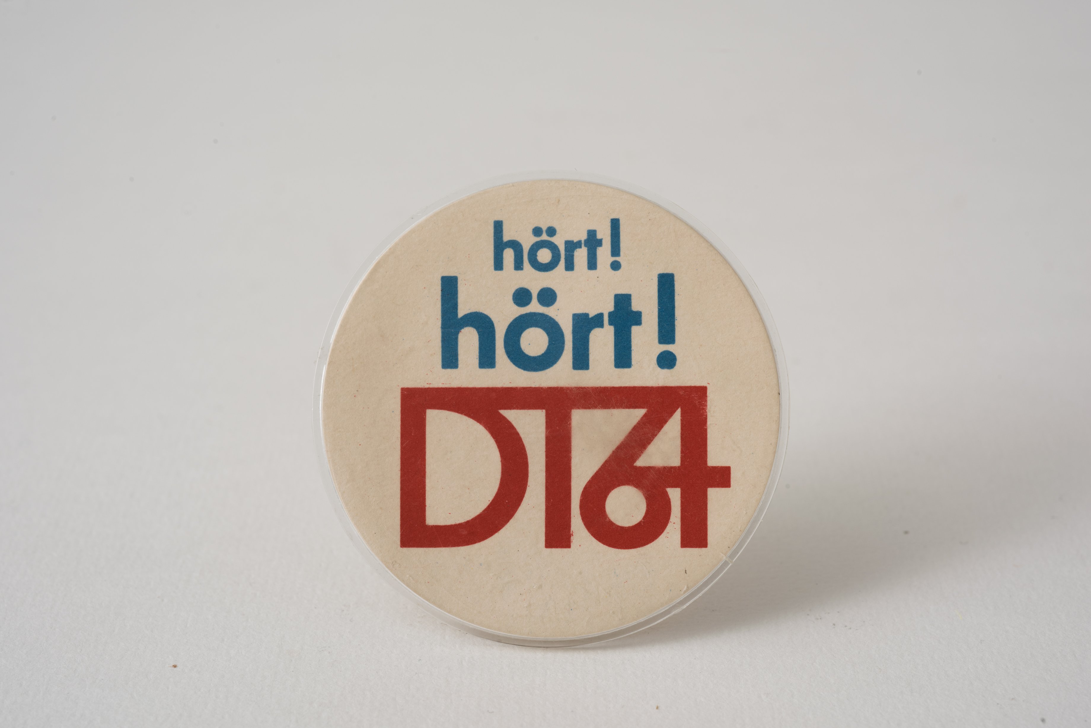 Ansteckpin "DT64" (Museum Utopie und Alltag. Alltagskultur und Kunst aus der DDR CC BY-NC-SA)