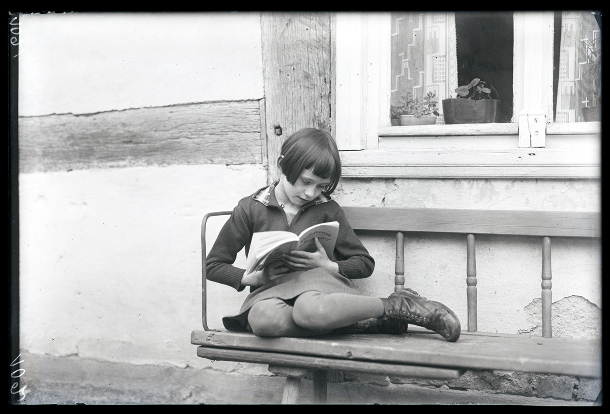 Lesendes Mädchen auf einer Bank (Wegemuseum Wusterhausen/Dosse CC BY-NC-SA)
