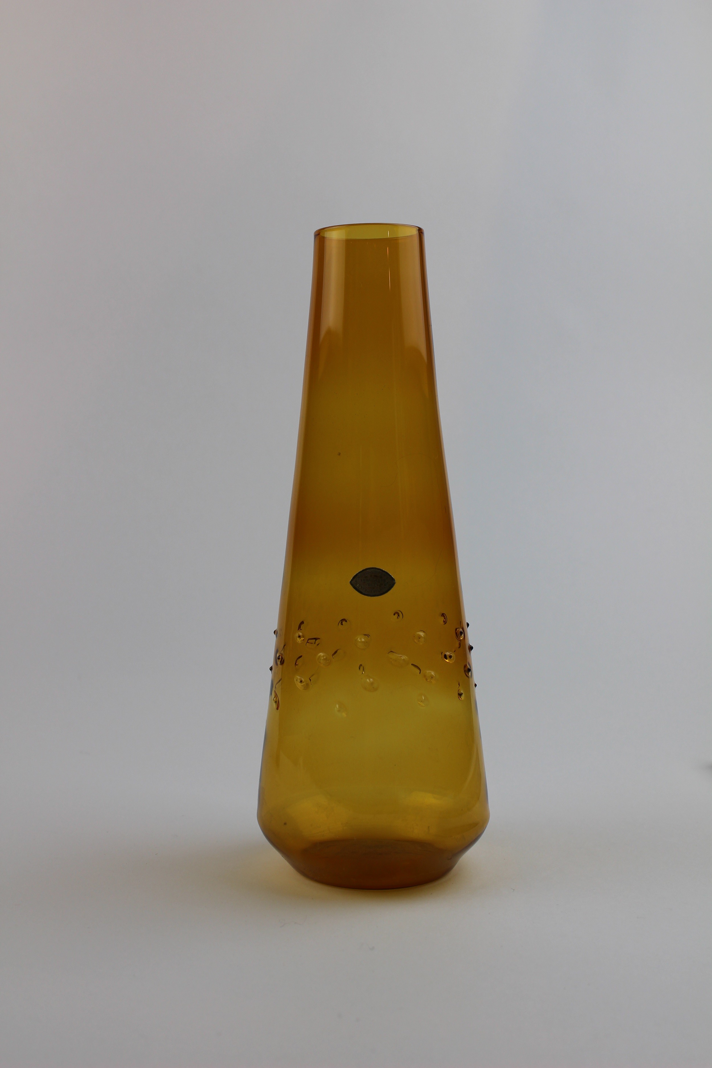 Bernsteinfarbene, konische Vase mit Aufkleber (Museum Baruther Glashütte CC BY-NC-SA)
