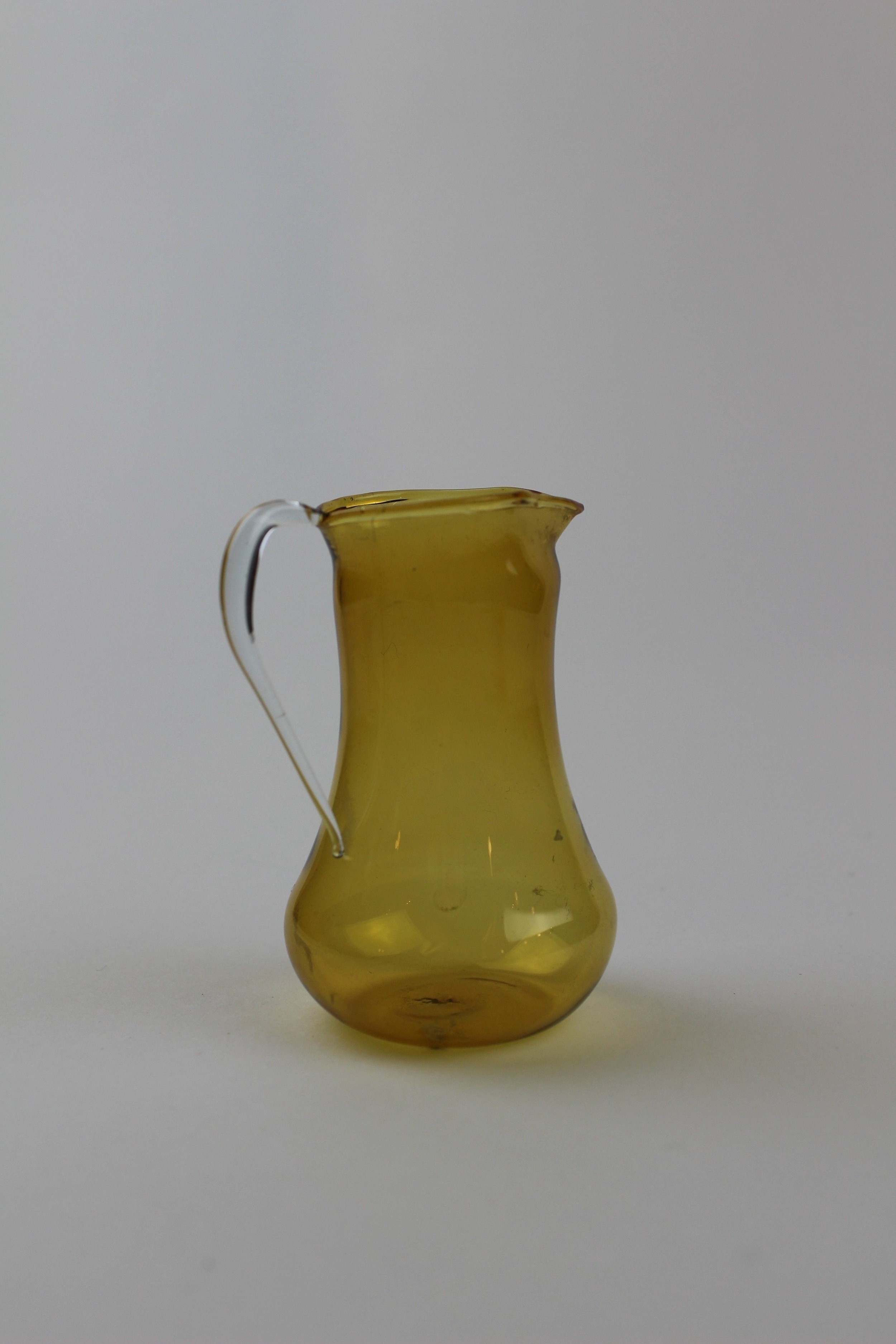 Bernsteinfarbene Vase/Glaskaraffe mit transparentem Henkel (Museum Baruther Glashütte CC BY-NC-SA)