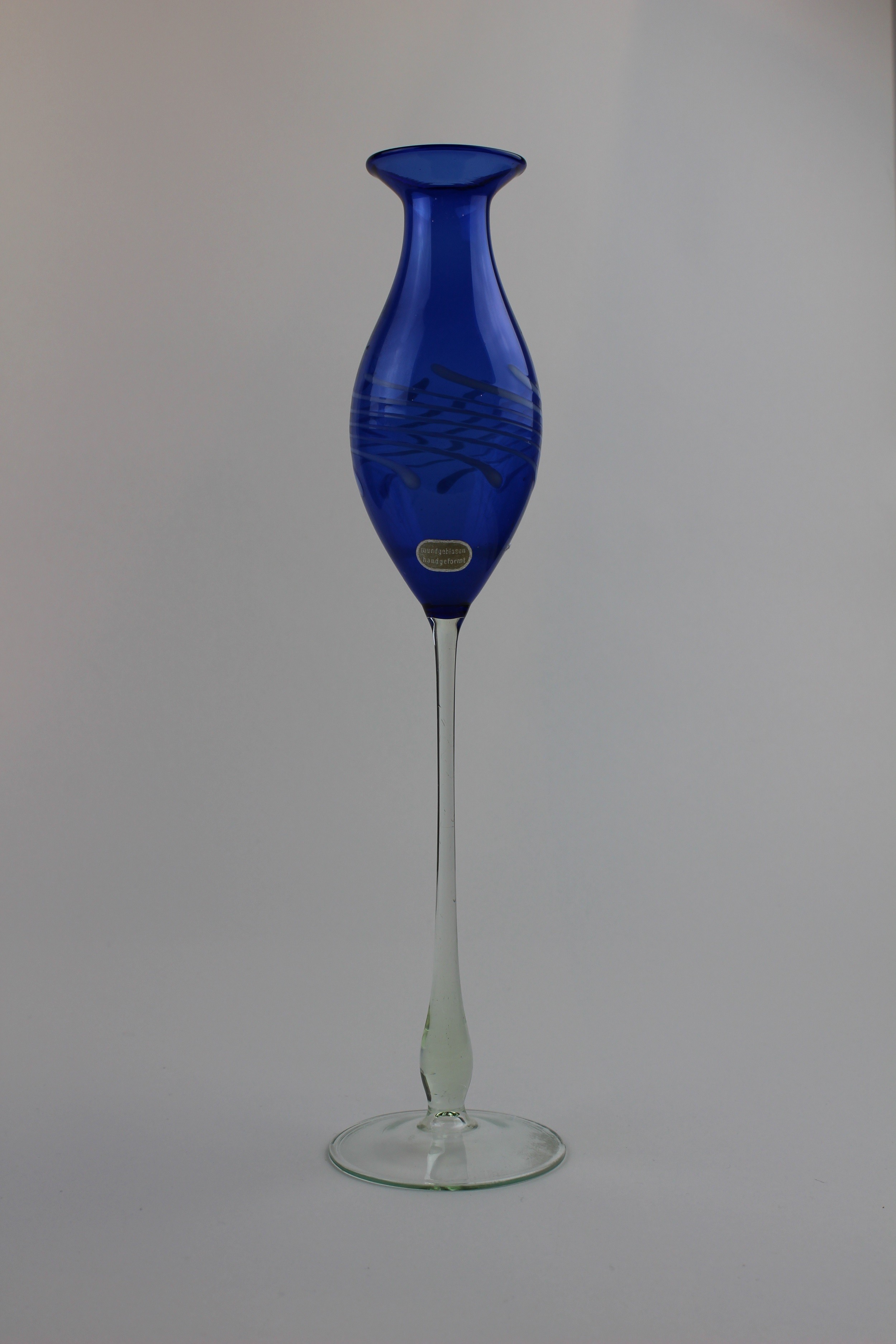 Montanblaue Vase/Trinkgefäß mit transparentem Stiel und Aufkleber (Museum Baruther Glashütte CC BY-NC-SA)