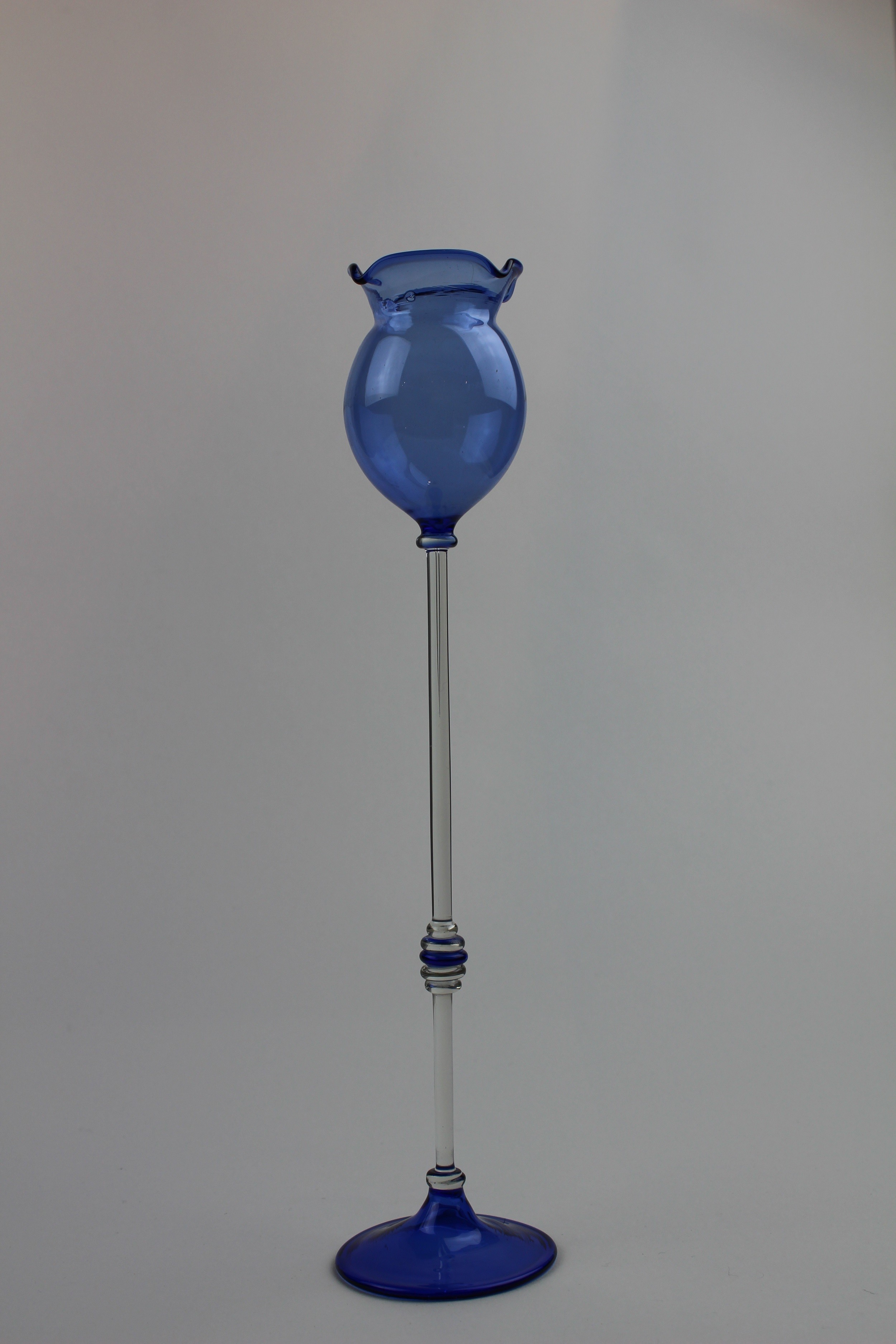 Montanblaue Vase/Trinkgefäß mit transparentem Stiel und Verzierungen (Museum Baruther Glashütte CC BY-NC-SA)