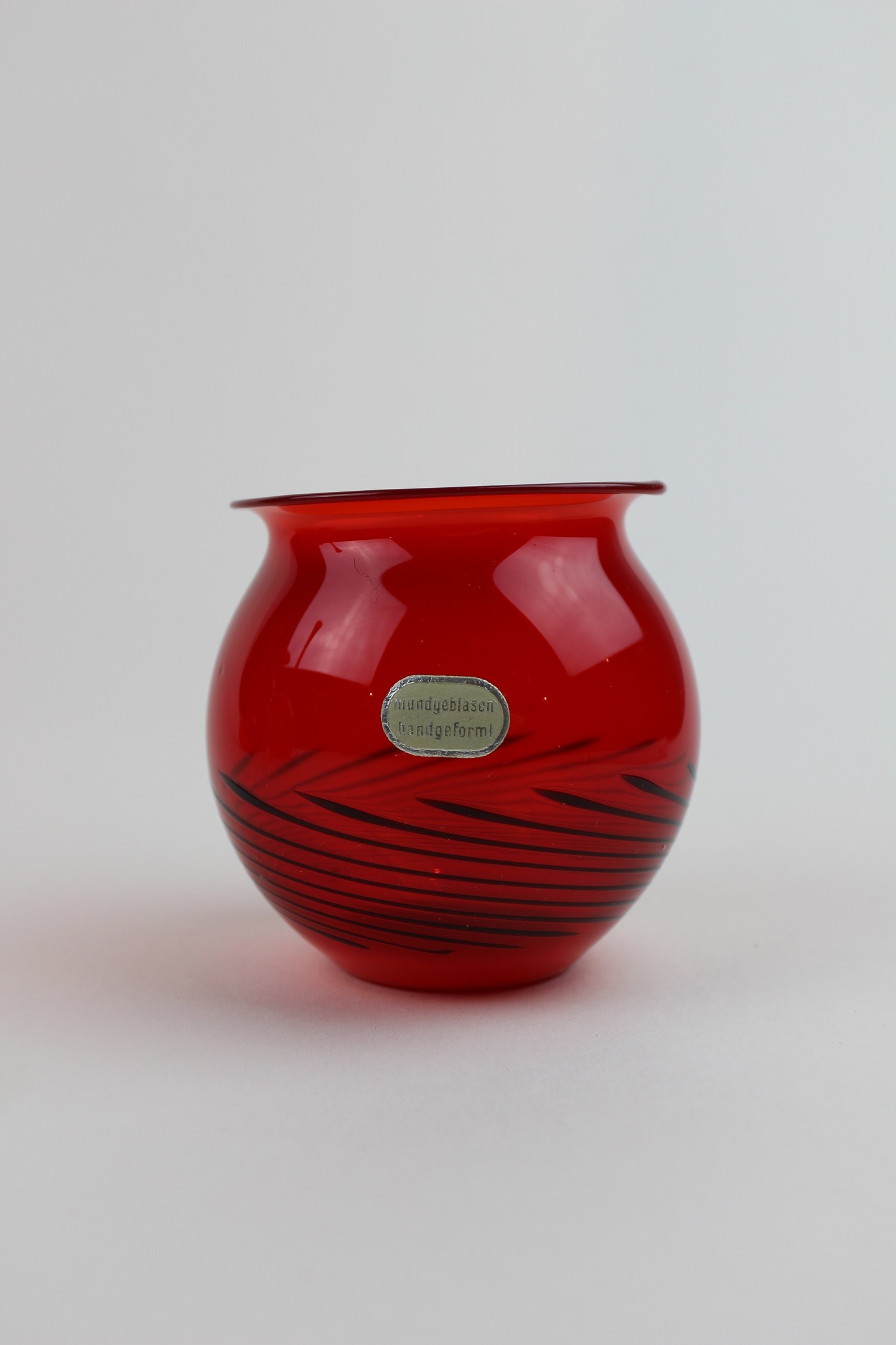Brilliantrubinrote Vase/Kerzenhalter mit schwarzem Muster und Aufkleber (Museum Baruther Glashütte CC BY-NC-SA)