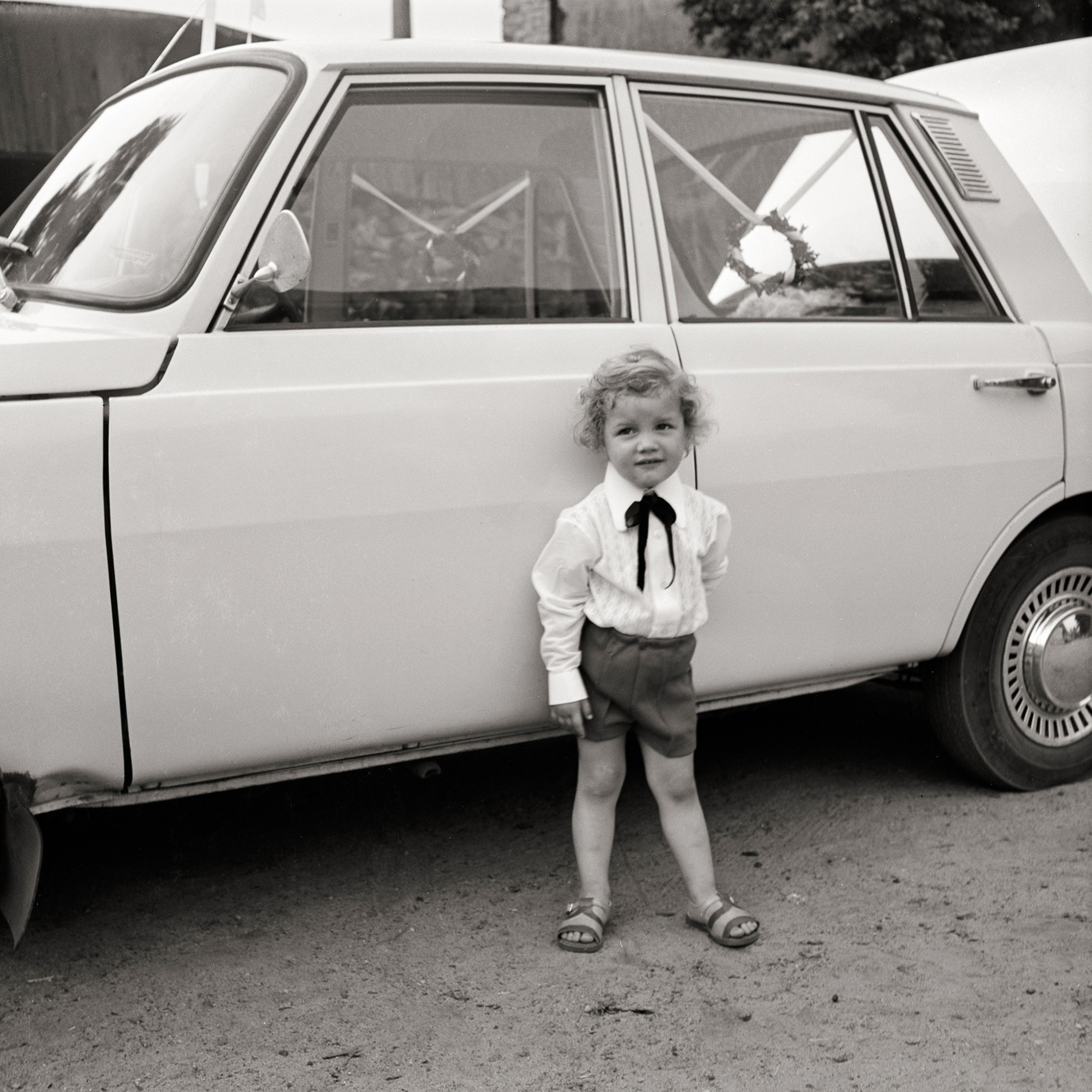 Fotografie eines Jungen vor einem Auto (Müllroser Heimatmuseum im Haus des Gastes CC BY-NC-SA)