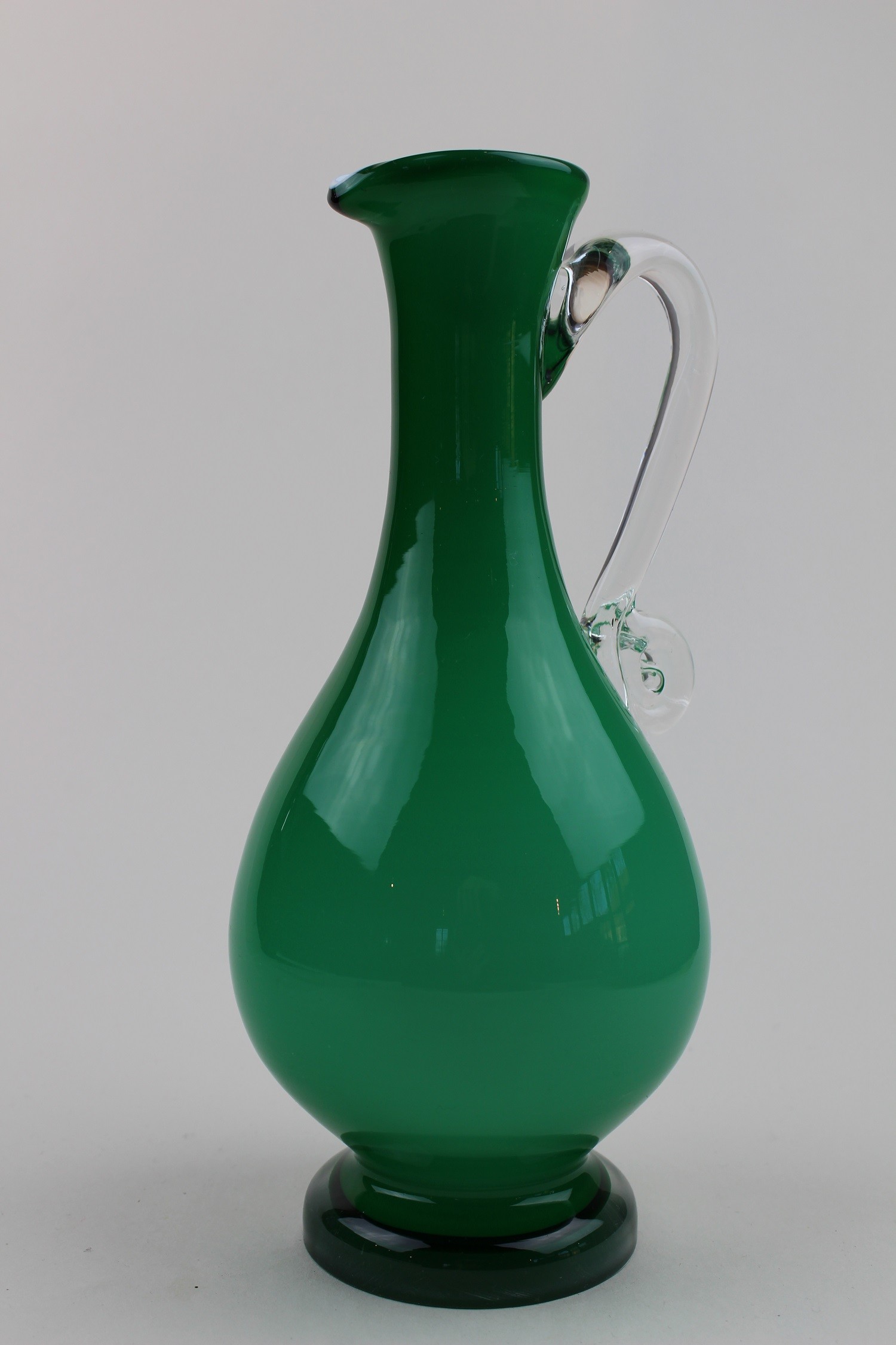 Grünliche Vase/Karaffe mit farblosem Henkel (Museum Baruther Glashütte CC BY-NC-SA)