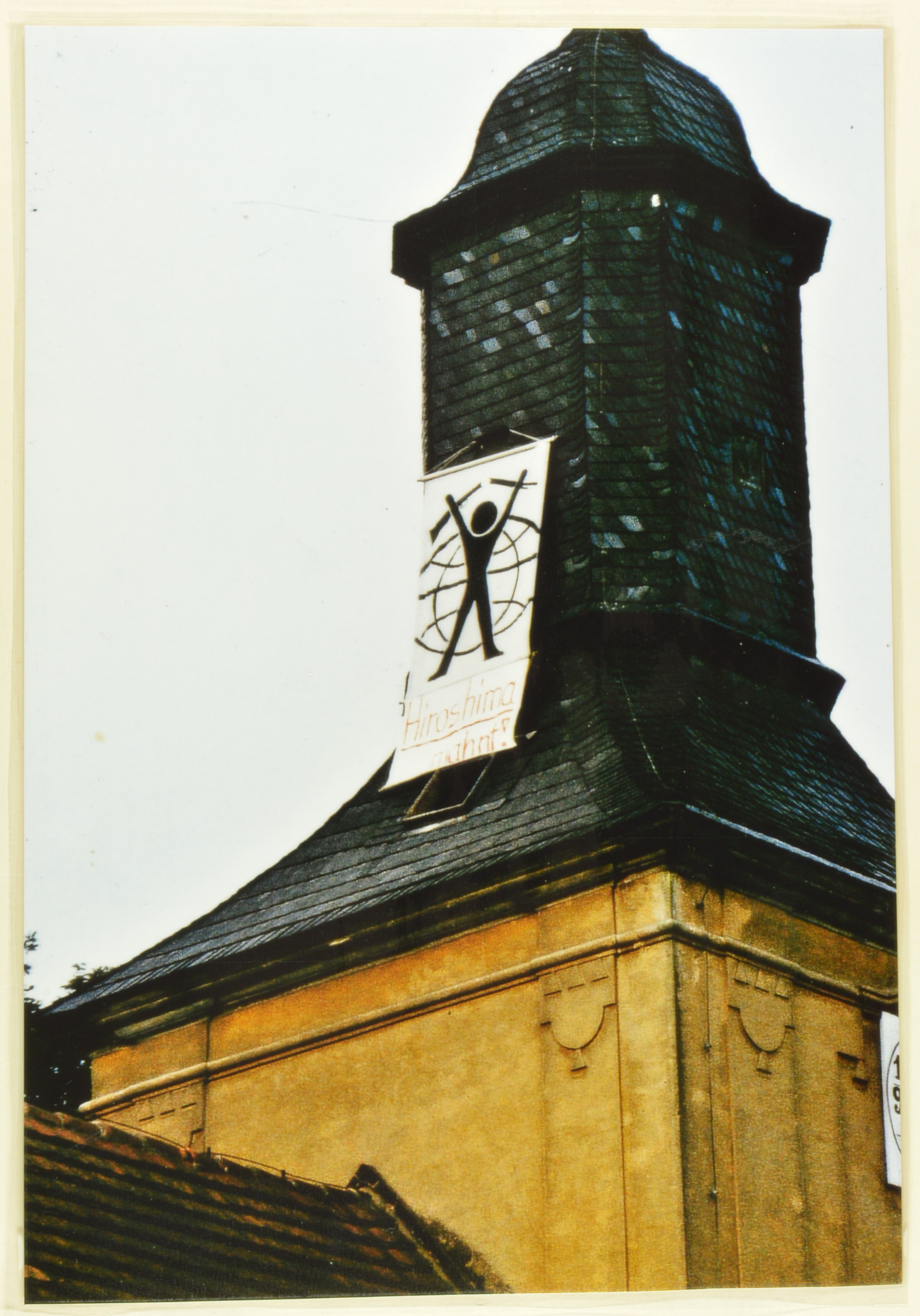 Transparent am Turm der Köritzer Kirche: Mann vor Weltkugel (DDR Geschichtsmuseum im Dokumentationszentrum Perleberg CC BY-SA)