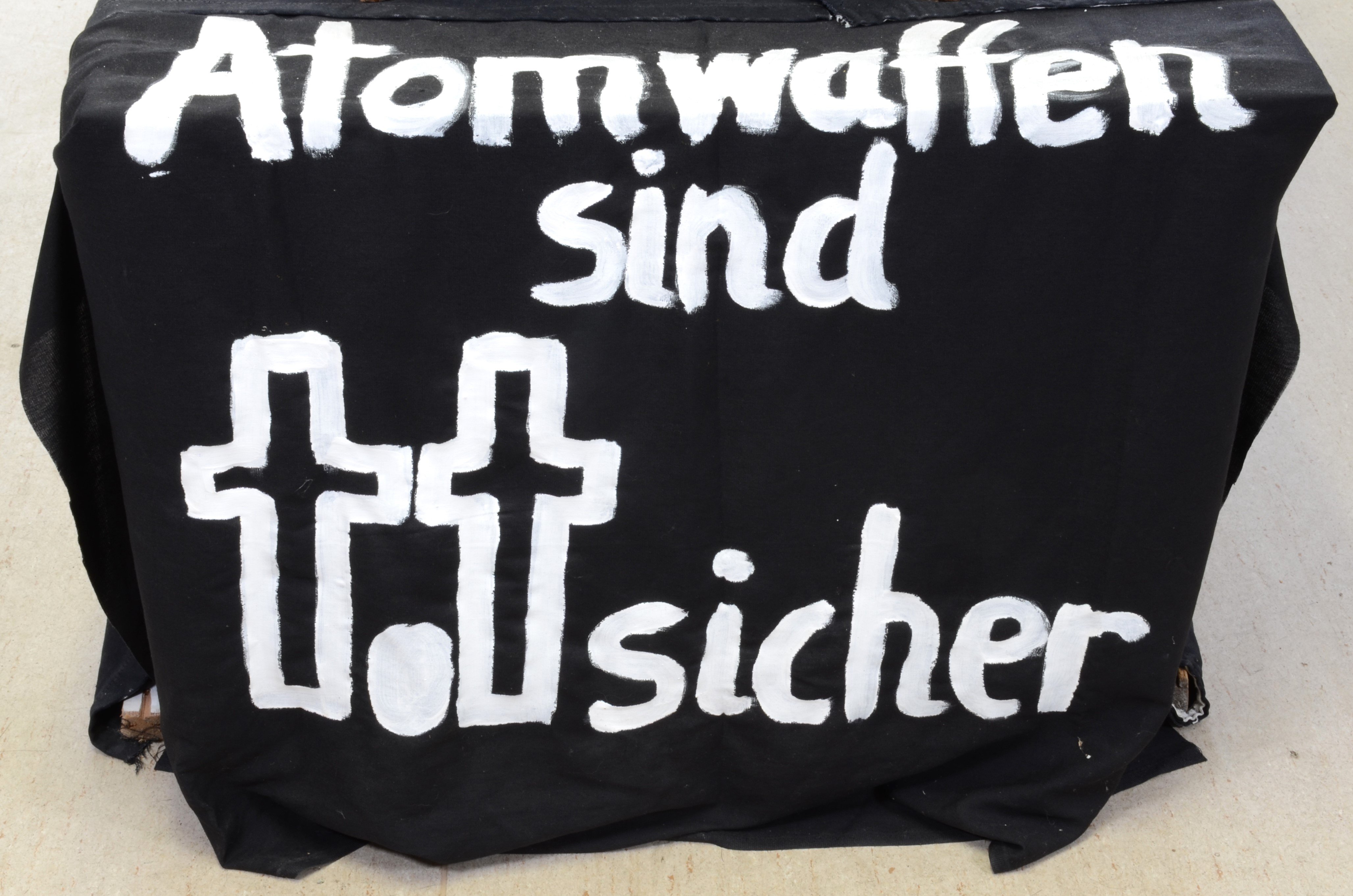 Transparent: "Atomwaffen sind totsicher" für den Protest gegen die Atomschlagübung "Dosse 83" (DDR Geschichtsmuseum im Dokumentationszentrum Perleberg CC BY-SA)