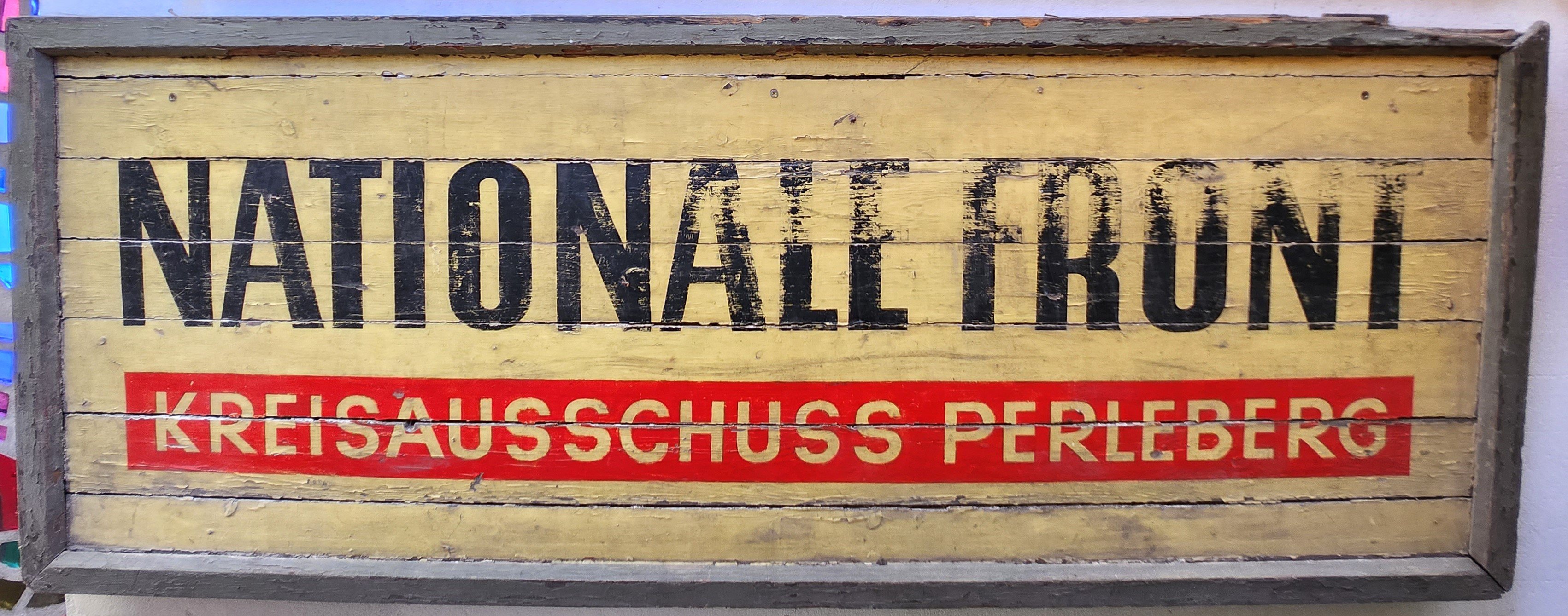 Schild: "Nationale Front, Kreisausschuß Perleberg" (DDR Geschichtsmuseum im Dokumentationszentrum Perleberg CC BY-SA)