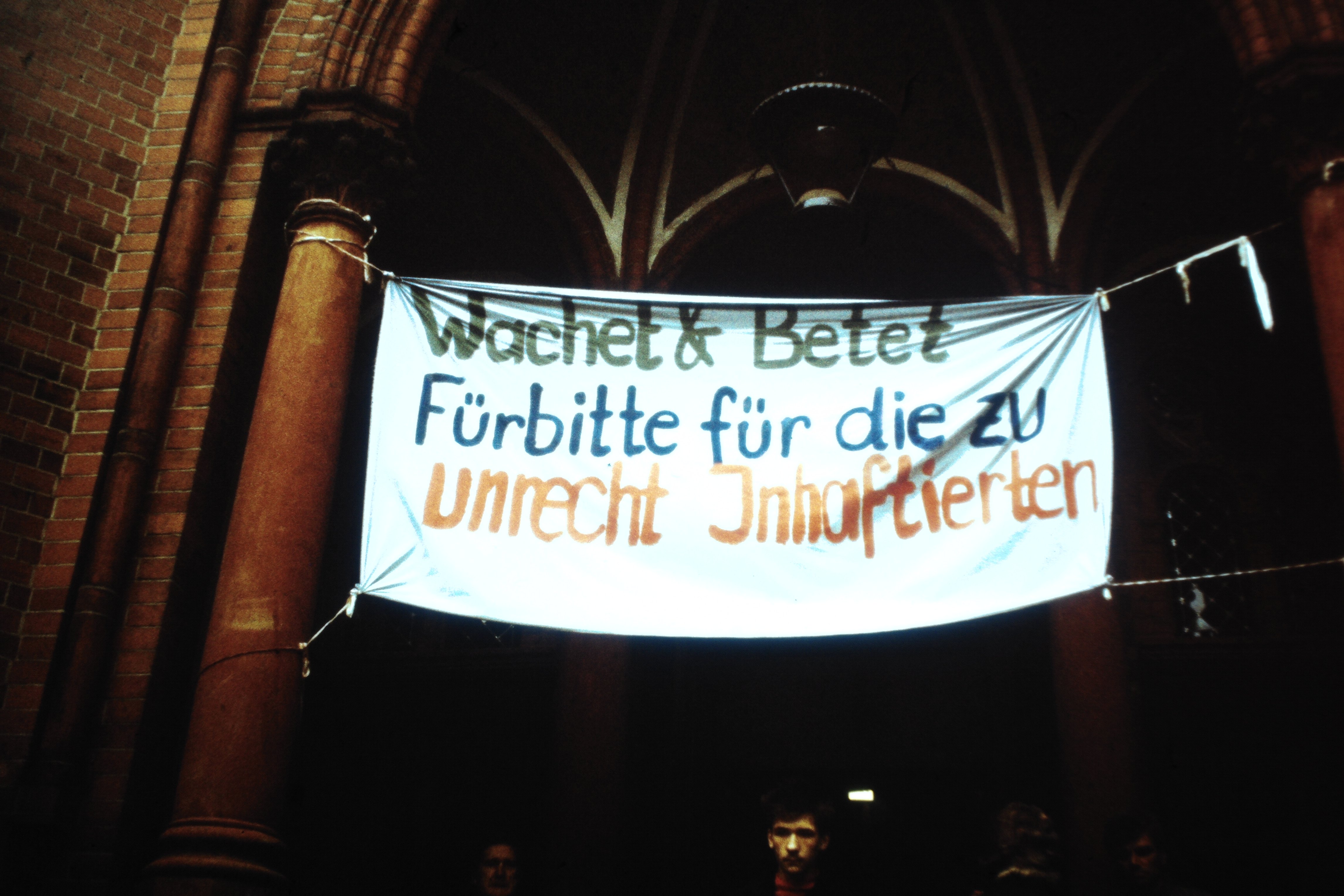 Gethsemanekirche in Berlin: Transparent mit der Aufschrift: "Wachet & Betet Fürbitte für die zu unrecht Inhaftierten" (DDR Geschichtsmuseum im Dokumentationszentrum Perleberg CC BY-SA)