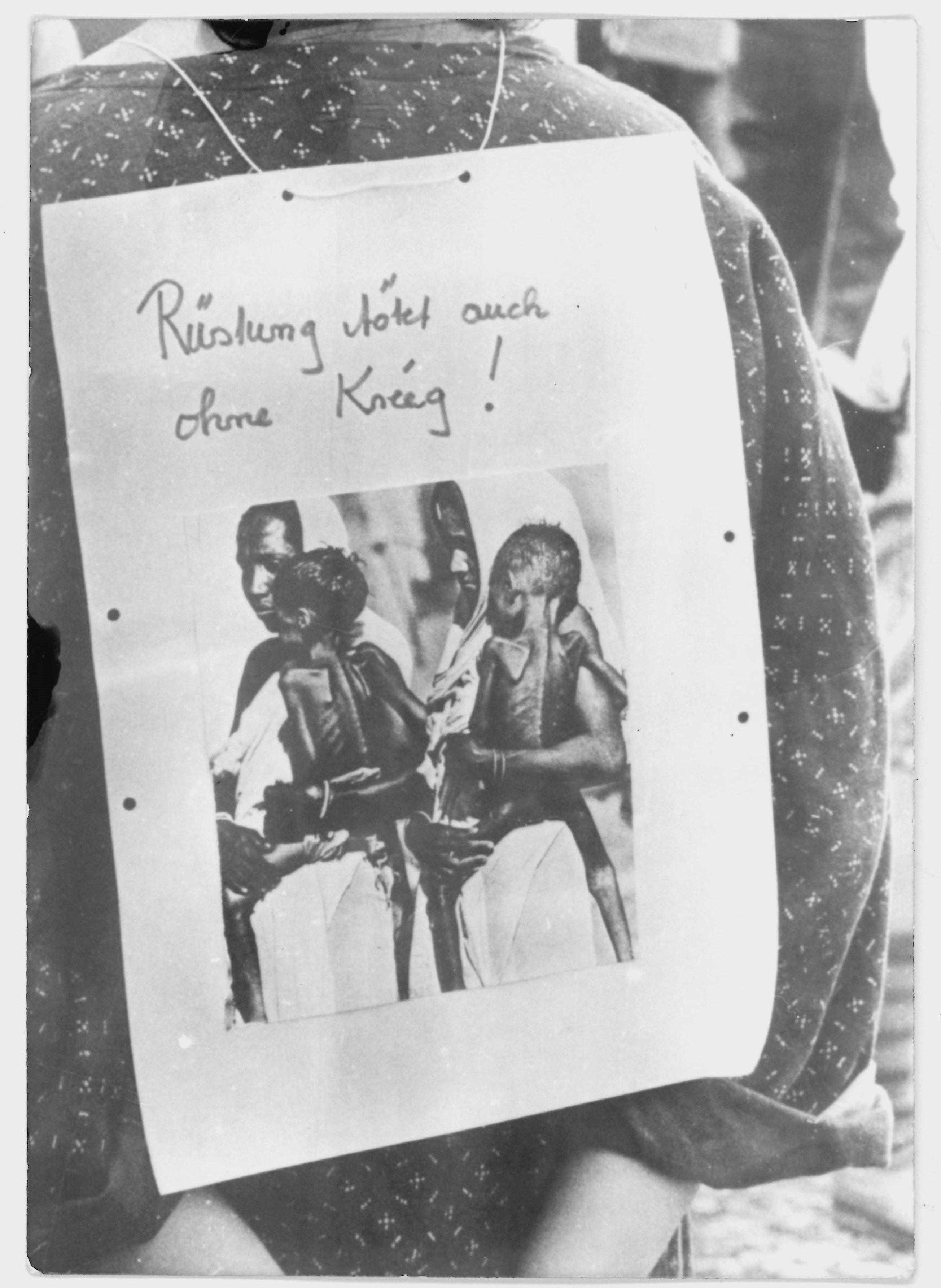 Olof-Palme-Marsch 1987: Teilnehmerin mit einer Fotografie und dem Spruch: "Rüstung tötet auch ohne Krieg" (DDR Geschichtsmuseum im Dokumentationszentrum Perleberg CC BY-SA)