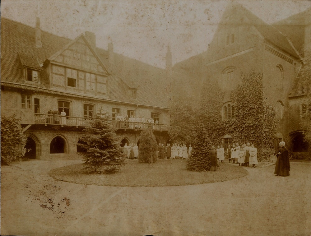 Äbtissin von Rohr mit Stiftskindern und -damen im Klosterhof (Museum Kloster Stift zum Heiligengrabe CC BY-NC-SA)