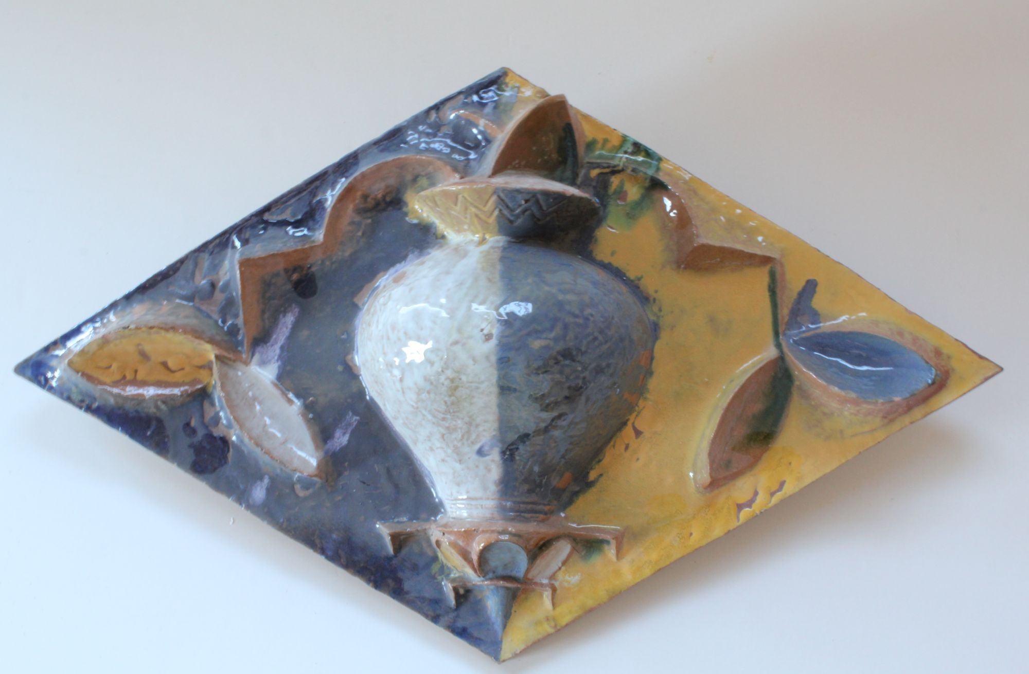 Schmuckkachel in Rautenform mit Blattmotiv und Vase (Ofen- und Keramikmuseum Velten CC BY-NC-SA)